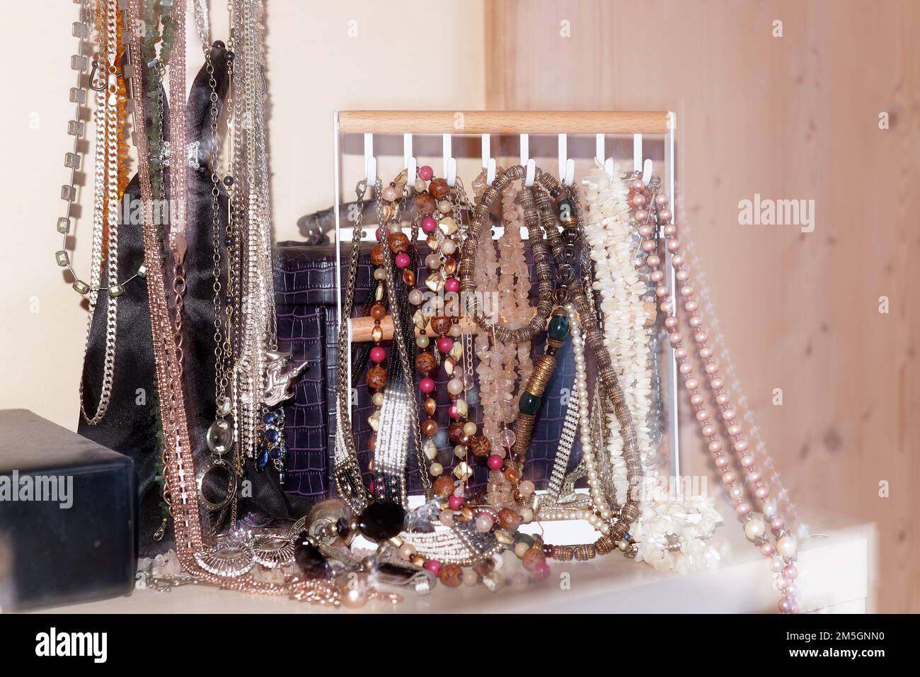 Bijoux fantaisie, nombreuses chaînes sur un support à bijoux Banque D'Images