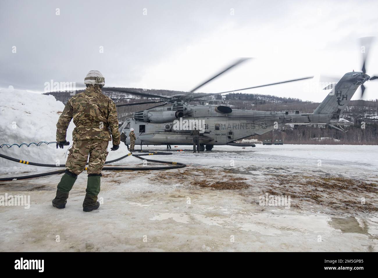 Un marin de la Marine royale du Royaume-Uni aide à faire le plein d'un super étalon CH-53E pendant l'exercice Cold Response 2022, champ d'aviation d'Elvenes, Norvège, 17 mars 2022. L'hélicoptère est affecté à l'escadron 366 de l'hélicoptère marin lourd et le marin de la Marine royale est affecté à la Force de l'hélicoptère Commando. L’exercice Cold Response ’22 est un exercice biennal qui a lieu dans toute la Norvège, avec la participation de chacun de ses services militaires, ainsi que de 26 autres nations alliées et partenaires régionaux de l’Organisation du Traité de l’Atlantique Nord. Banque D'Images