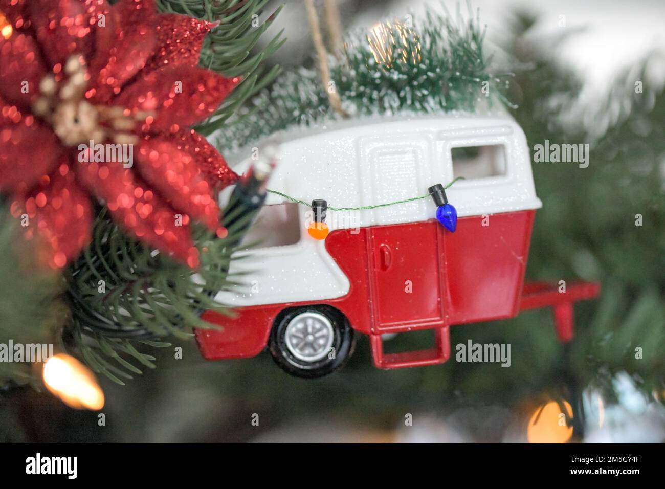 Décoration d'arbre de Noël rouge et blanc avec un arbre de Noël sur son toit et une rangée de lumières suspendues le long de son côté Banque D'Images