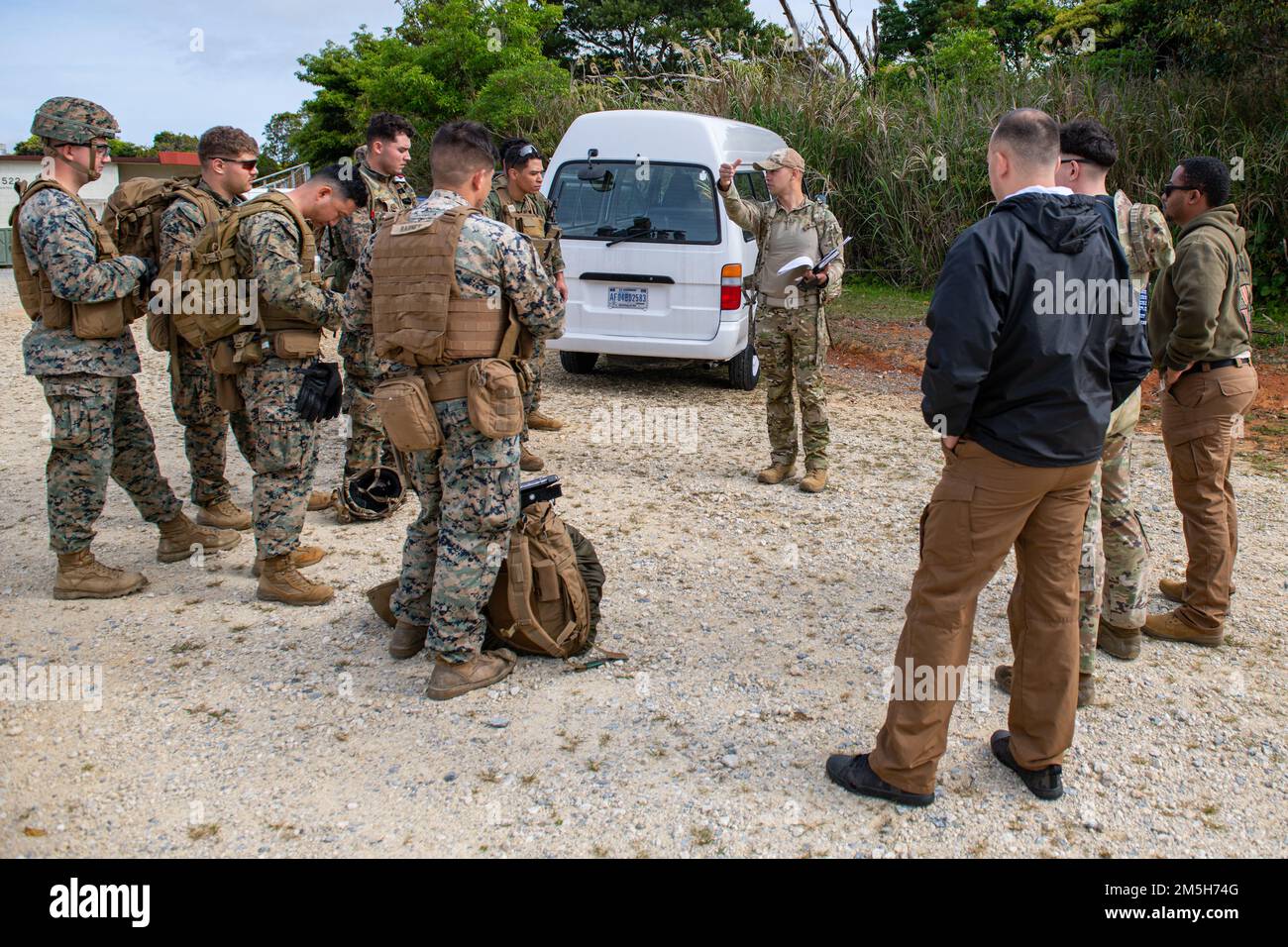 ÉTATS-UNIS Tech. De la Force aérienne Sgt Kenji Scouton, 18th escadron de soutien des opérations NCO, responsable des opérations de survie, d'évasion, de résistance et d'évasion, Explique le plan de capture des pilotes de chasse de l'escadre 18th qui se cachent dans la jungle de l'équipe de chiens de travail militaires de l'escadron des forces de sécurité 18th et de la compagnie de liaison des tirs de la Marine corps 5th au Centre d'entraînement de la guerre Jungle du corps des Marines, Camp Gonsalvez, Japon, 18 mars 2022. L'opération conjointe a été dirigée par les NCO de la SERE, ce qui a permis aux marines et à de nombreux autres membres du personnel de la Force aérienne d'acquérir des compétences dans de nombreux scénarios de la SERE. Banque D'Images