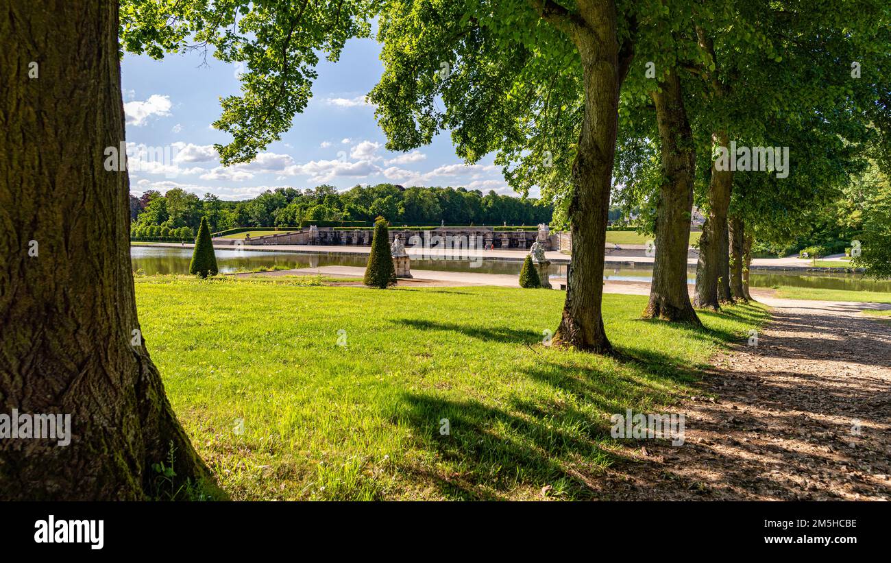 Maincy, France - 21 mai 2022 : une rangée de sycomores et un étang rectangulaire dans un jardin classique français (Vaux-le-Vicomte). Photo prise tôt Banque D'Images