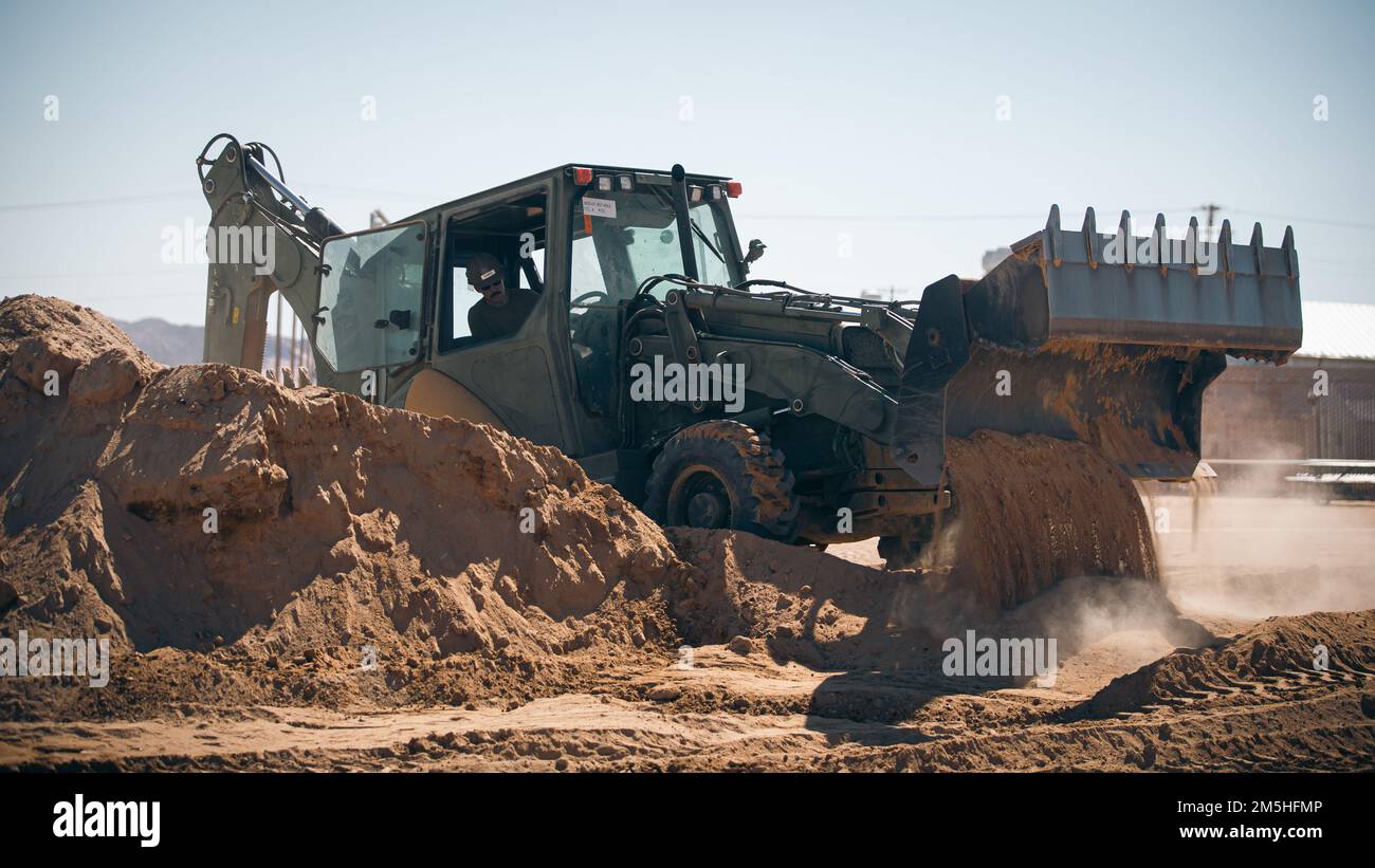 A ÉTATS-UNIS Marin avec le détachement de 29 Palms, le bataillon de construction mobile navale 4 exploite une pelle rétro CAT 420 au centre de combat aérien du corps maritime, à Twentynine Palms, en Californie, en 17 mars 2022. La nouvelle installation offrira une autre option aux membres du service au sein de l'auditoire de la formation pour trouver un répit à l'égard des contraintes des exercices de formation au niveau du service. Banque D'Images