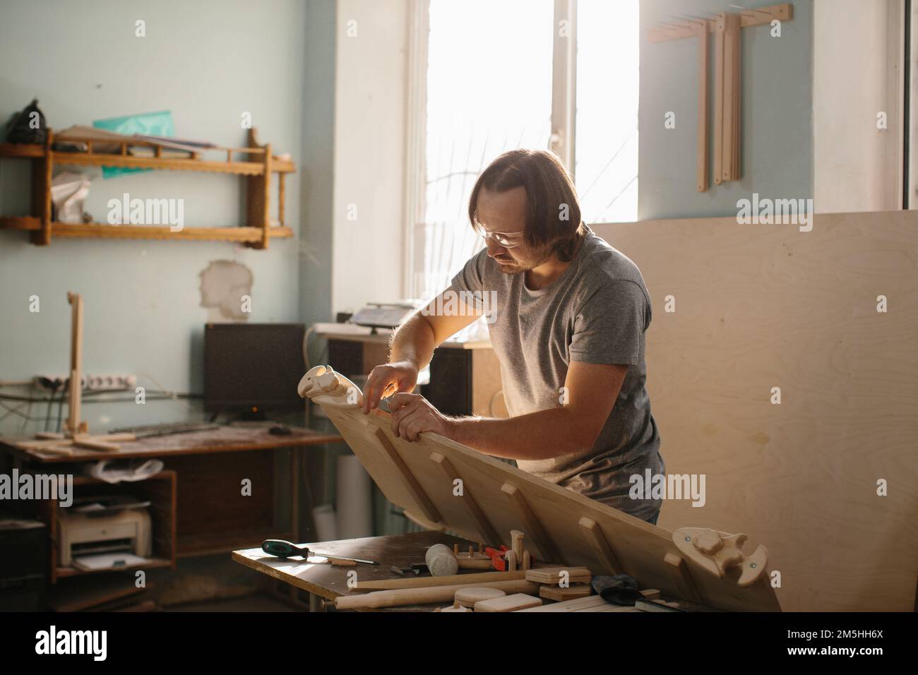 Un charpentier adulte, homme travaillant avec des outils dans sa boutique de bois - photo de stock Banque D'Images