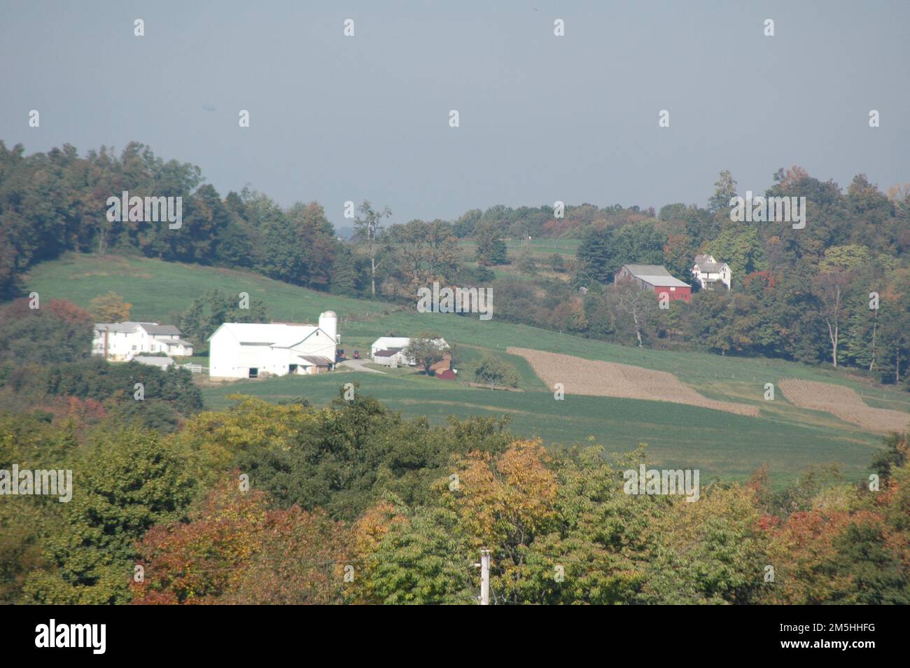 Amish Country Byway - Hazy Farm dans le comté de Holmes. L'automne commence tout juste à venir dans les forêts entourant cette ferme blanche dans le pays Amish de l'Ohio. Lieu: Holmes County, Ohio (40,601° N 81,744° O) Banque D'Images