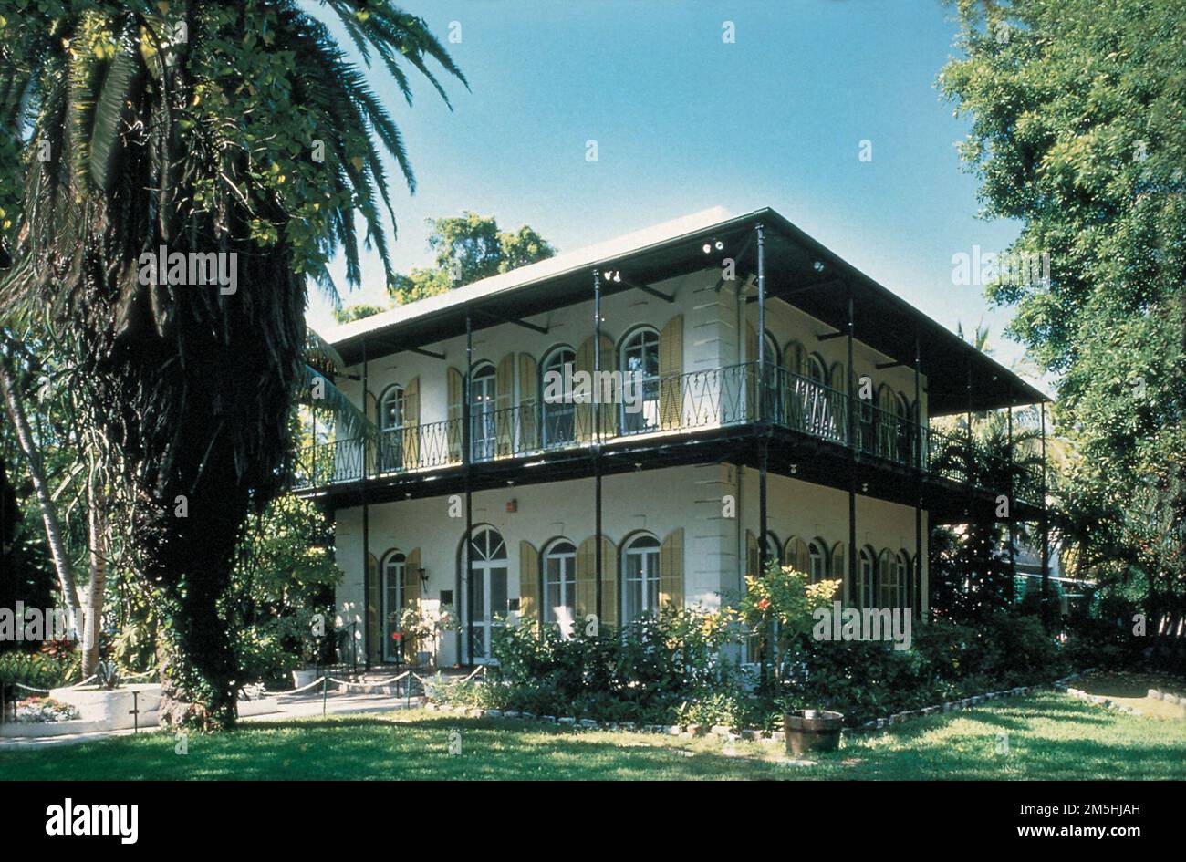 Route panoramique Florida Keys - Maison et musée Ernest Hemingway. La maison et le musée Ernest Hemingway à Key West, FL, sur la route panoramique Florida Keys, est une maison de deux étages de style colonial espagnol avec de grandes fenêtres voûtées de chaque côté des deux étages et une véranda enveloppante au deuxième étage. Emplacement : Key West, Floride (24,551° N 81,801° O) Banque D'Images