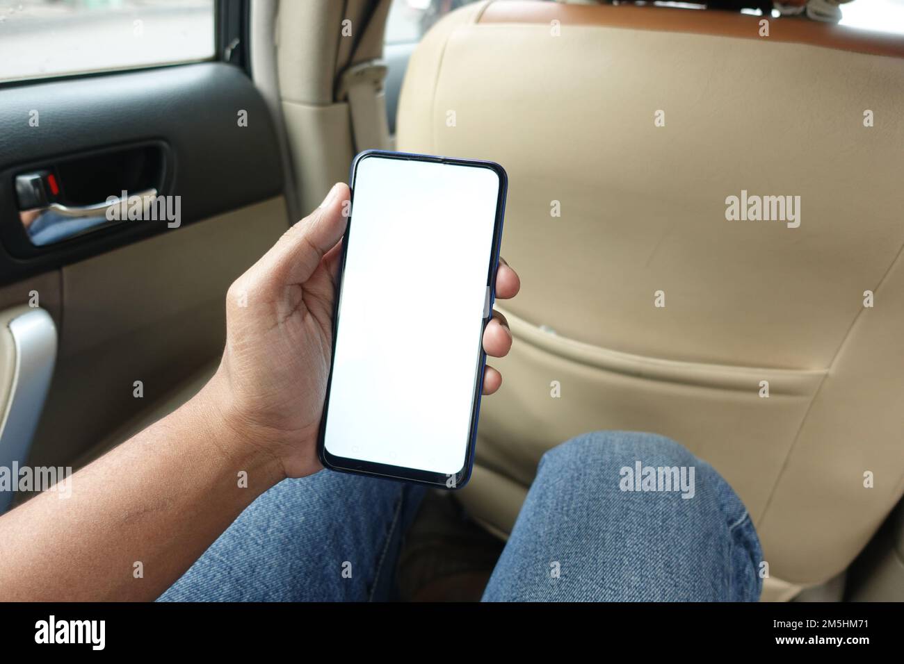 main tenant un smartphone avec écran vide dans une voiture Banque D'Images