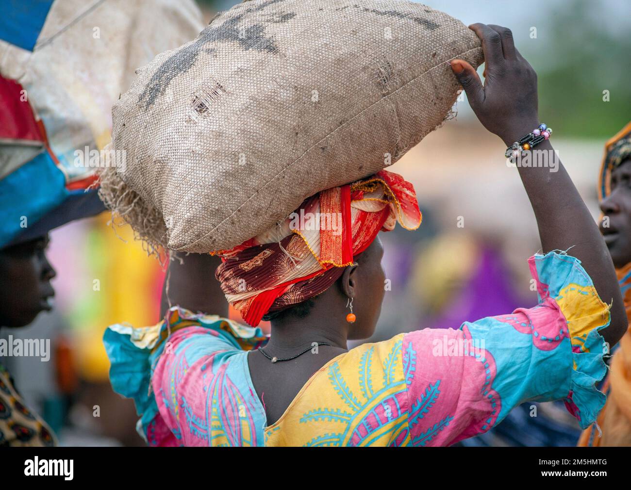 Femme porte sac de sucre sur sa tête au marché à Djenne, Mali, Afrique. Banque D'Images