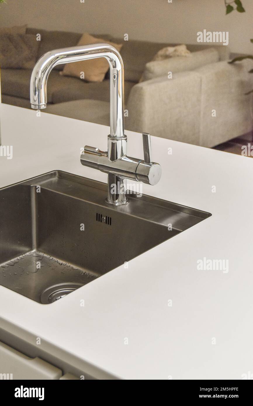 un évier de cuisine avec de l'eau qui coule du robinet de fausé dans il est  tenu à la main droite au-dessus de l'évier Photo Stock - Alamy