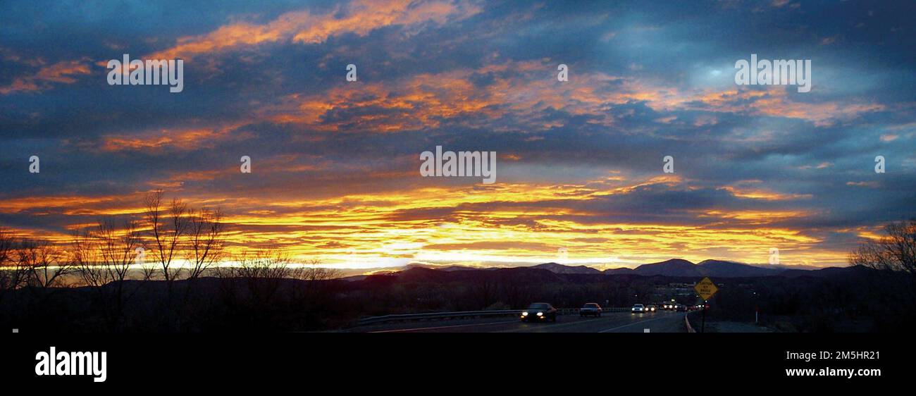 El Camino Real - coucher de soleil sur les montagnes Jemez depuis le pont Valdez. Un coucher de soleil glorieux offre une fin spectaculaire à la journée pour les conducteurs à domicile. On peut presque sentir leur soulagement en traversant le Rio Grande sur leur chemin de retour. Beaucoup de résidents de la vallée de l'Española peuvent retrouver leurs racines à l'époque de O&ntilde et pour les Indiens Pueblo encore plus loin. Comme leurs ancêtres des siècles passés, ils voyagent toujours El Camino chez eux. Lieu: El Camino Real, Nouveau-Mexique (32,314° N 106,747° O) Banque D'Images
