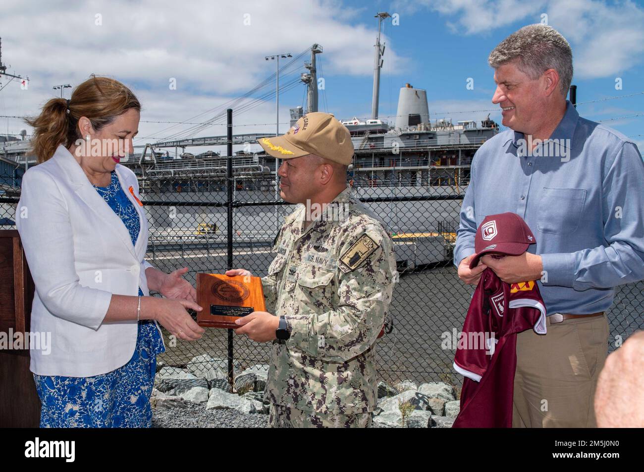 BRISBANE, Australie (18 mars 2022) – le capitaine Al Alarcon, commandant de l’émory S. l’agent sous-marin de classe terrestre USS Frank Cable (AS 40), présente au Premier ministre du Queensland Annastacia Palaszczuk un cadeau de l’équipage à la suite d’une conférence de presse sur l’aide apportée par Frank Cable à l’opération Flood Assist, 18 mars. Les marins de Frank Cable et les marins de la fonction publique du Commandement du Seallift militaire travaillent actuellement côte à côte avec les Forces de défense australiennes pour éliminer les débris des zones touchées autour de Brisbane dans le cadre de l'opération Flood Assist. Frank Cable est en patrouille pour la maintenance expéditionnaire et logi Banque D'Images