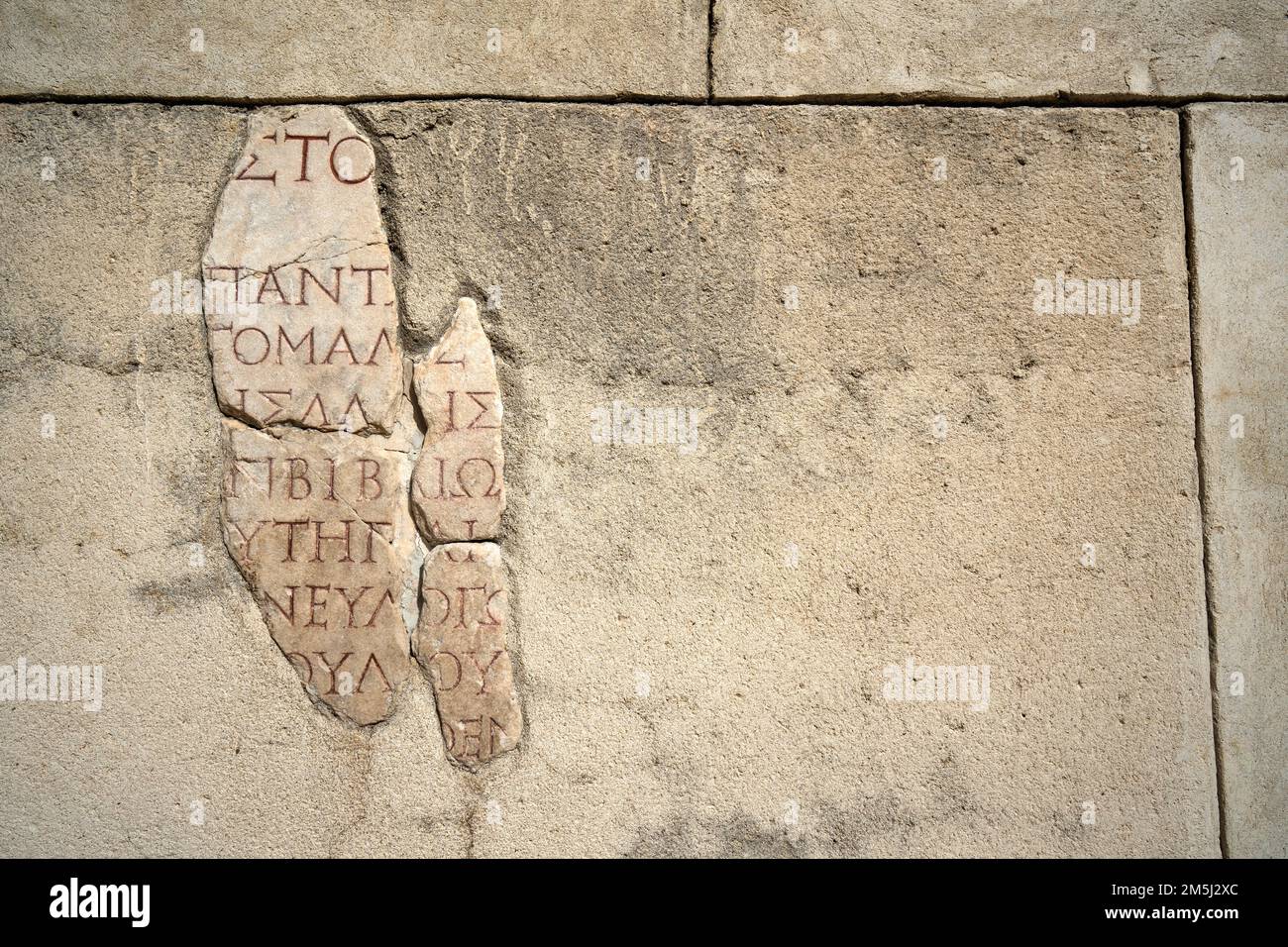 Fragment d'une ancienne inscription grecque sculptée en marbre. Banque D'Images