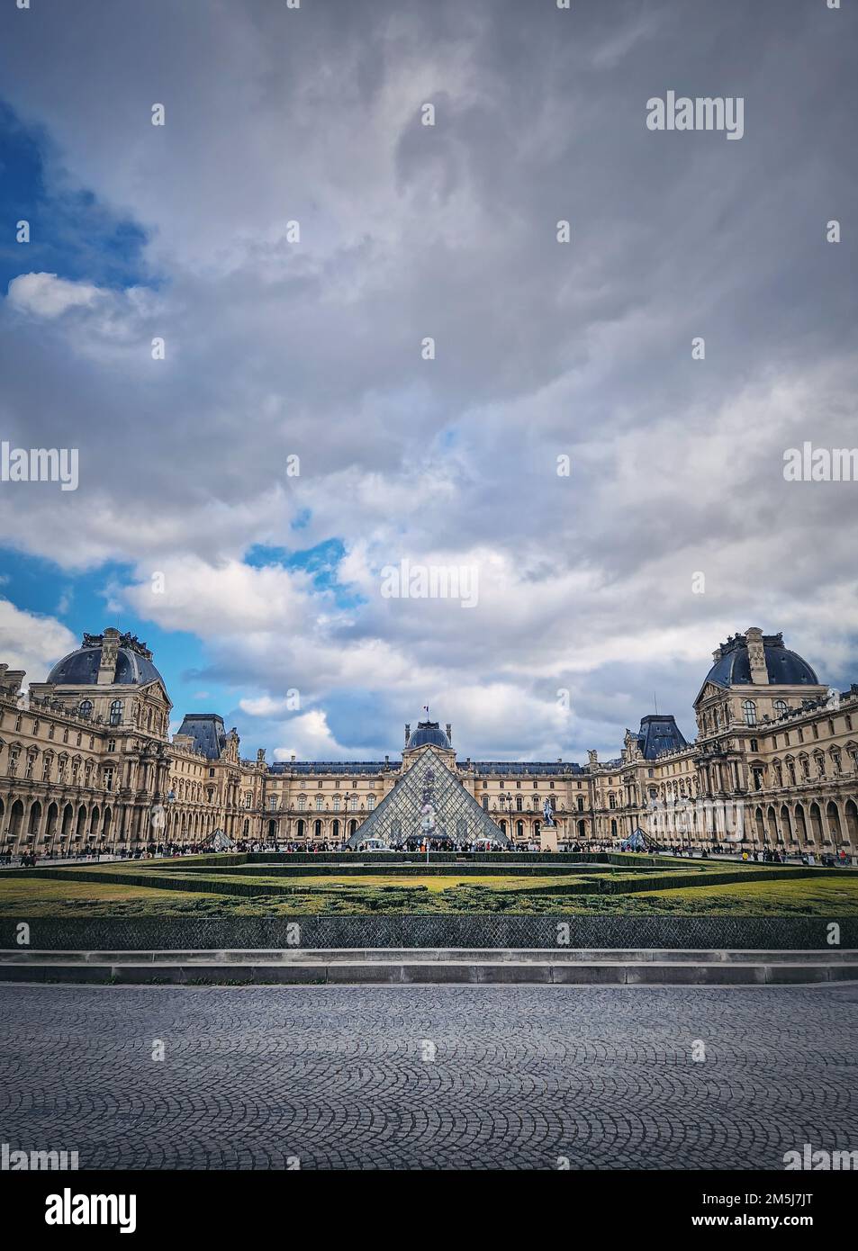 Vue extérieure sur le Musée du Louvre à Paris, France. Le palais historique avec la pyramide moderne en verre au centre, arrière-plan vertical Banque D'Images