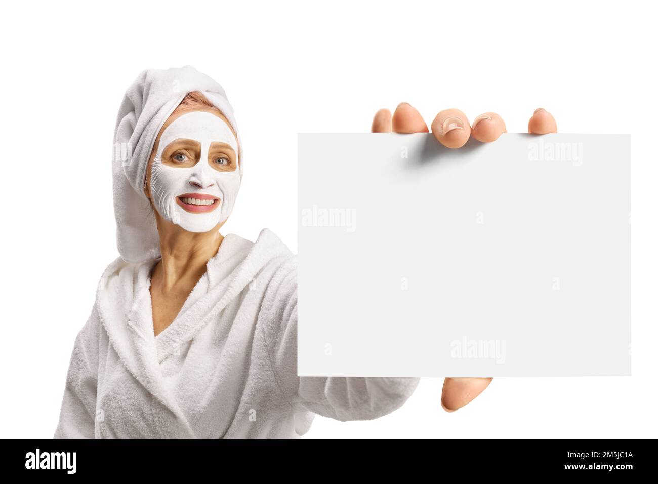 Femme dans un peignoir avec un masque facial tenant un carton vierge isolé sur fond blanc Banque D'Images
