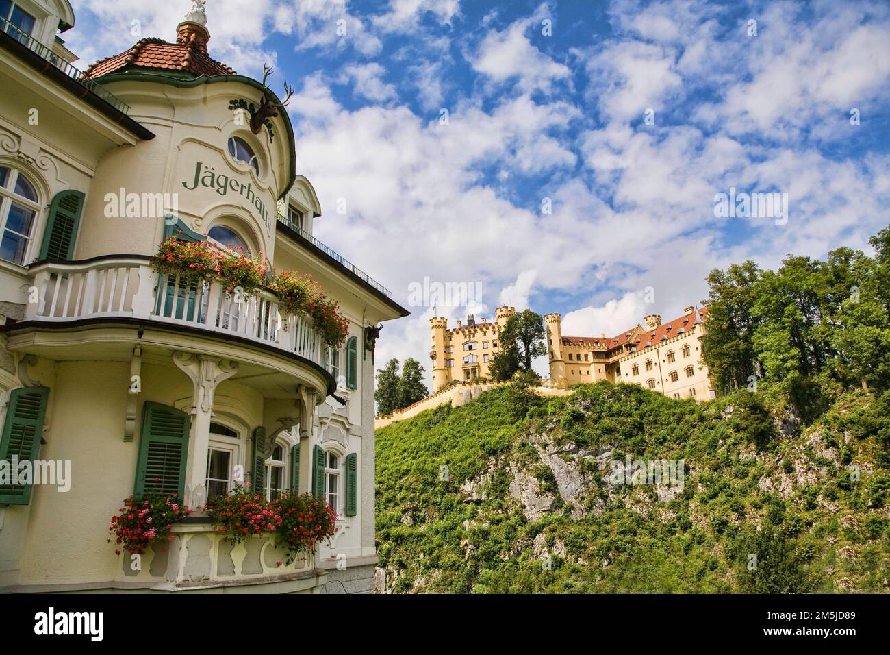 Château de Hohenschwangau domine la ville à sa base et l'hôtel Jagerhaus, Allemagne. Banque D'Images