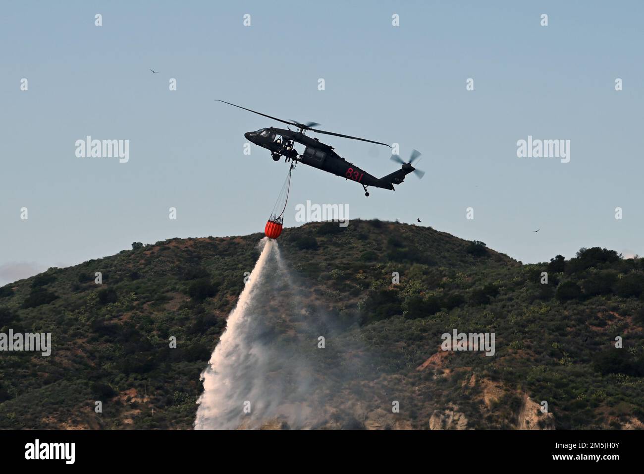 A ÉTATS-UNIS L'hélicoptère UH-60M Black Hawk de l'armée, piloté par des soldats du Bataillon des hélicoptères d'assaut 1st, 140th Aviation Regiment, de la Garde nationale de l'armée de Californie, dépose un seau d'eau lors d'une formation aérienne de lutte contre les incendies de forêt avec le ministère de la foresterie et de la protection contre les incendies de Californie, 19 mars 2022, à Silverado, en Californie. CAL Guard et CAL FIRE ont un partenariat de plusieurs décennies pour lutter contre les grands feux de forêt de Californie. Banque D'Images