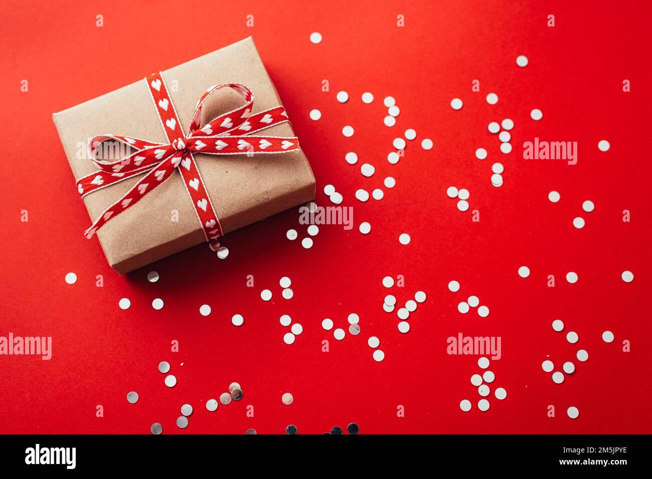 boîte cadeau le jour de la saint-valentin sur fond rouge. Banque D'Images