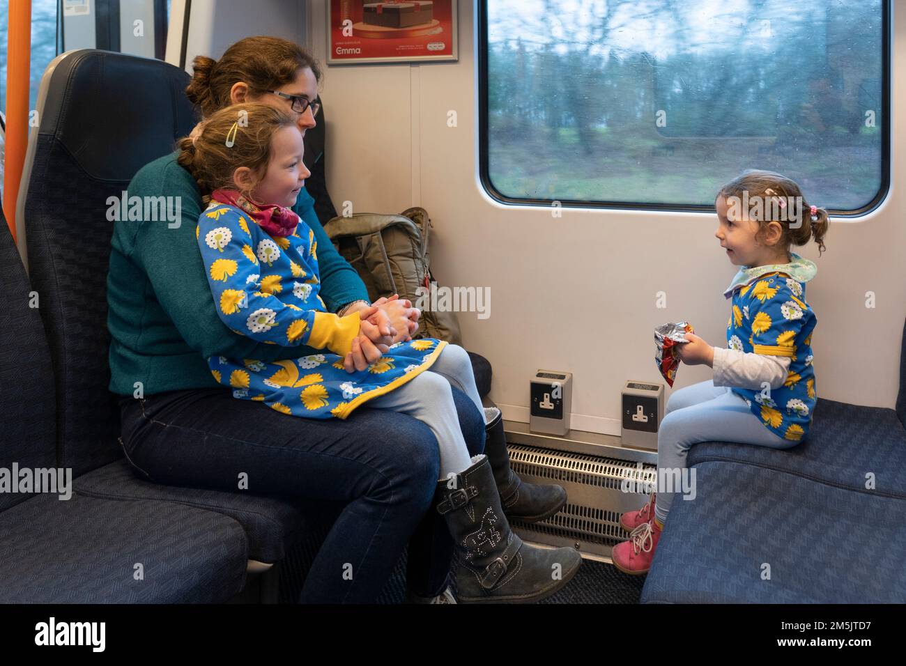 Une mère et ses filles s'asseyent et se déplacent dans une voiture à bord d'un train de Basingstoke à Londres en Angleterre. Concept: Voyage en train Banque D'Images