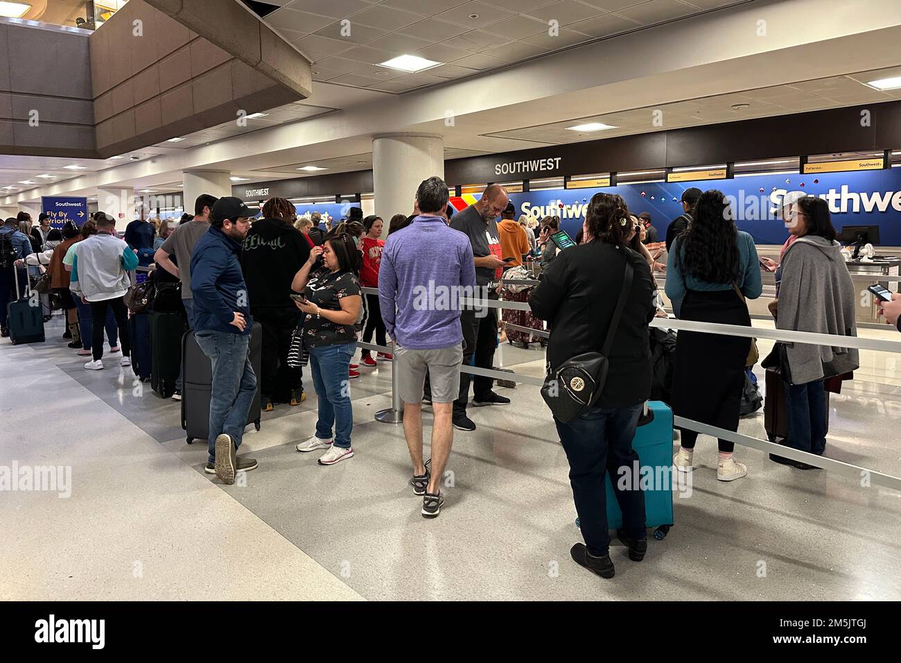 Les passagers attendent pour enregistrer leurs bagages au guichet de Southwest Airlines à l'aéroport international Sky Harbor, lundi 26 décembre 2022, à Phoenix. Banque D'Images