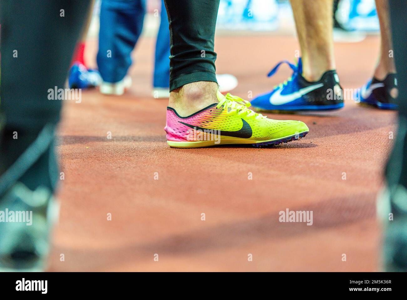 La chaussure de course Nike parmi les coureurs qui se rassemblent pour courir sur la piste du stade olympique. Chaussures d'entraînement Banque D'Images