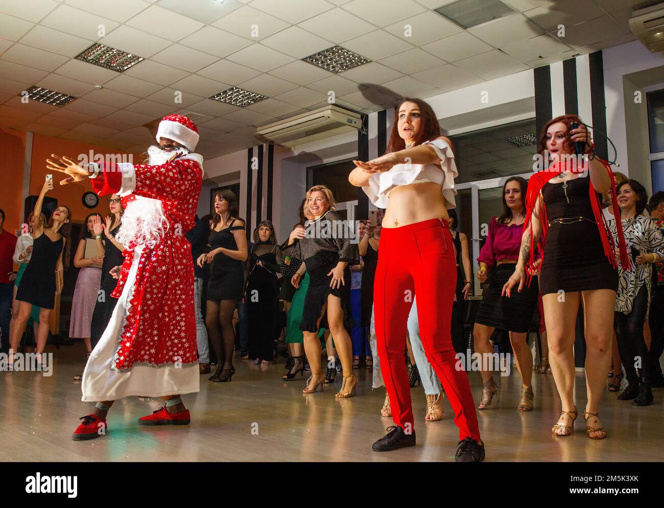 23-12-2022 Moscou, Russie. Professeur de danse afro-russe joue Ded Moroz (Père Noël. Grandfather Frost) et danse aussi avec le groupe - ils regardent t Banque D'Images