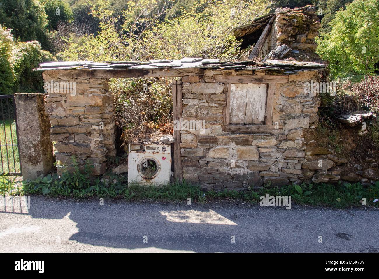La célèbre machine à laver a quitté les ruines d'une maison dans le village de Las Herrerias. En décades pendant de nombreuses années la machine dans la porte vide c'est une photo classique du Camino de Santiago pris par de nombreux pèlerins sur le chemin de la Galice. Banque D'Images