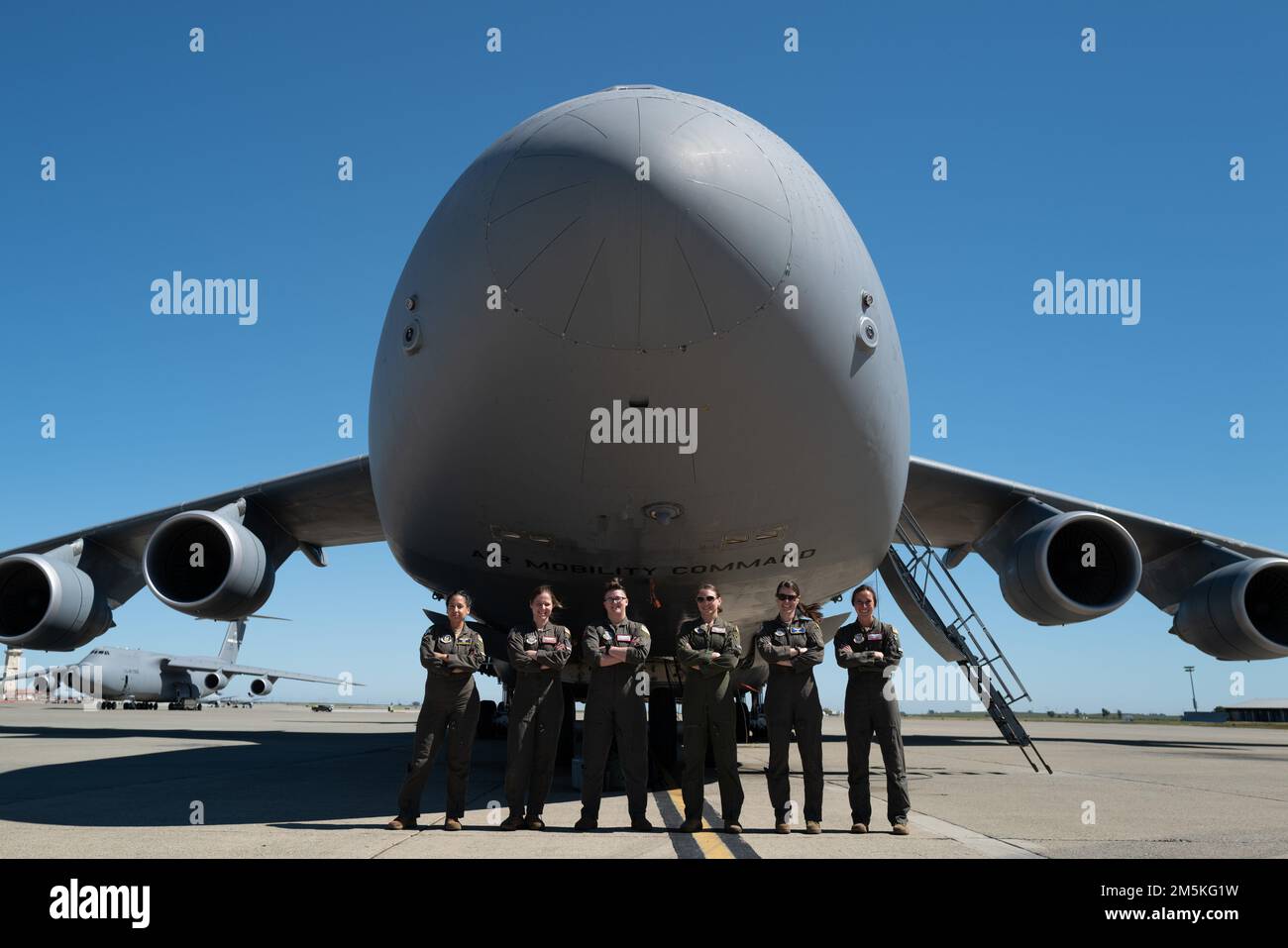 ÉTATS-UNIS Les pilotes de la Force aérienne C-5M Super Galaxy affectés à la base aérienne de Travis, en Californie, se rassemblent devant un C-5M à la base aérienne de Travis, en 22 mars 2022. Le C-5M transporte souvent plusieurs équipages et dispose de dispositions pour un maximum de 15 membres d'équipage de secours. Il peut également transporter 75 passagers supplémentaires dans des sièges de style avion séparés de l'espace de chargement. Banque D'Images