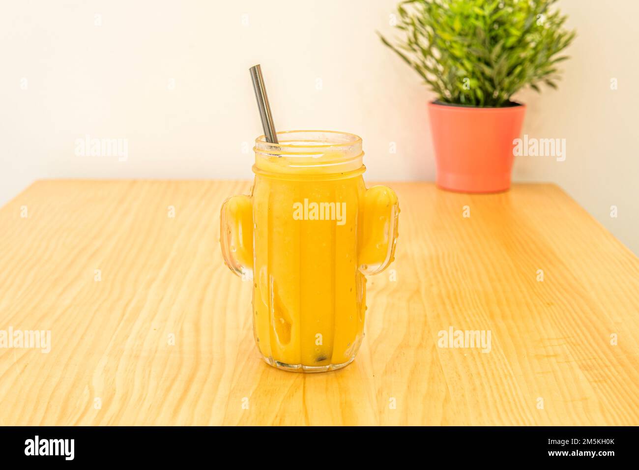 Un smoothie à l'ananas mûr dans un bol en verre sur une table en pin Banque D'Images