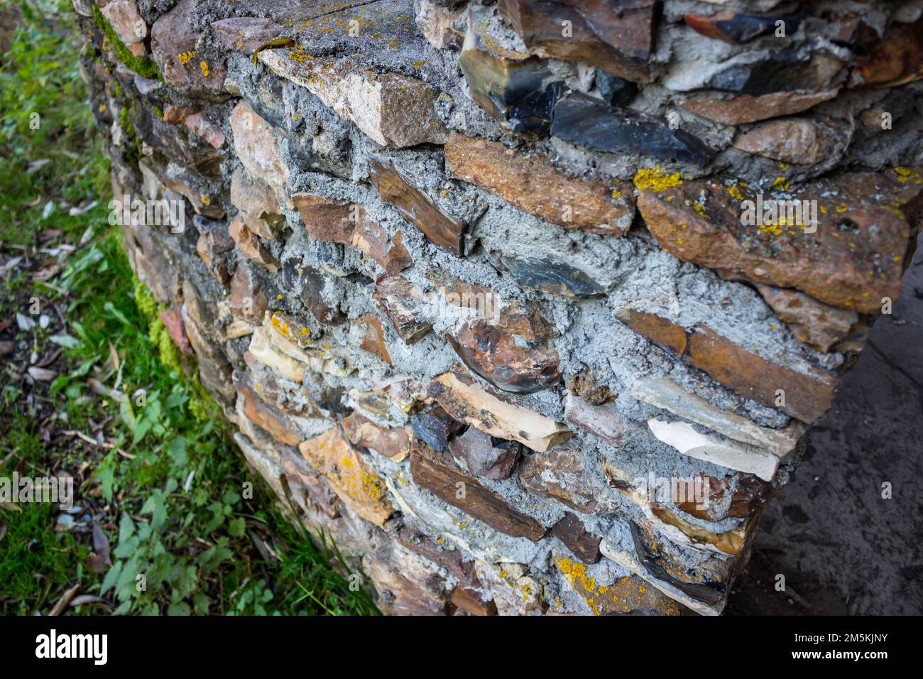 Fragment d'un mur construit de pierre brute sauvage et de mortier de ciment Banque D'Images