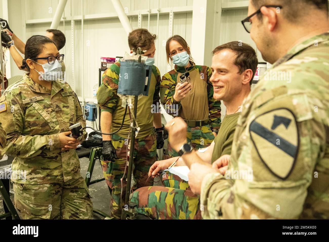 BASE AÉRIENNE DE MIHAIL KOGALNICEANU, ROUMANIE – ÉTATS-UNIS Armée Sgt. 1st classe Gorcyca et Pvt. 1st classe Ortiz de la 1st brigade de cavalerie aérienne vérifier les signes vitaux d'un soldat belge lors de la formation en transfusion sanguine à la base aérienne de MK, Roumanie, 22 mars 2022. Les transfusions sanguines aident à la réanimation sur le terrain en permettant à un médecin de prendre le sang d'une personne au point de la blessure et de l'infuser dans une victime blessée, ce qui améliorera considérablement ses chances de survie lorsqu'elle est transportée dans un centre chirurgical. Banque D'Images