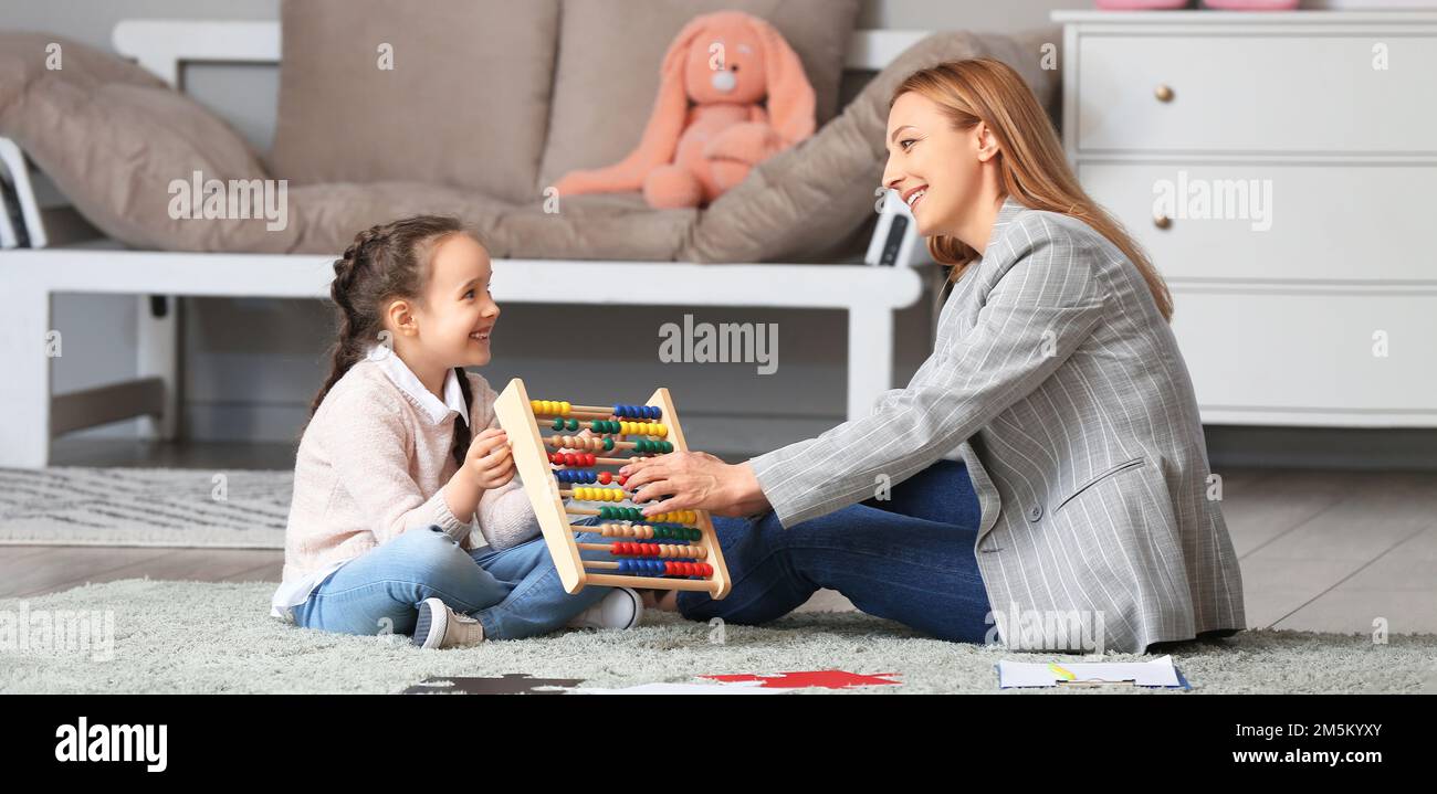 Psychologue féminine travaillant avec une fille souffrant de troubles autistes au bureau Banque D'Images