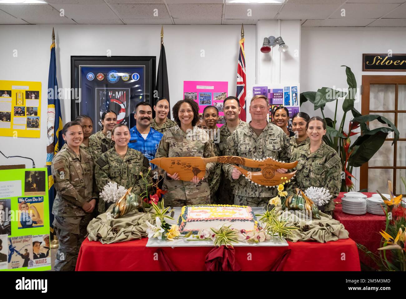 20220324-N-AS309-0001 HONOLULU (24 mars 2022) base conjointe Pearl Harbour-Hickam Commandant Captain Spitzer, CMDCM Smith, Chef de commandement Sergent-maître King, personnel de Galley, Et des femmes de la Marine et de l'Air Force présentent une épée de combat sur le thème hawaïen lors d'une cérémonie de découpe de gâteau célébrant le mois de l'histoire des femmes au Silver Dolphin Bistro Galley à bord de la base conjointe Pearl Harbor-Hickam Hawaii. Banque D'Images