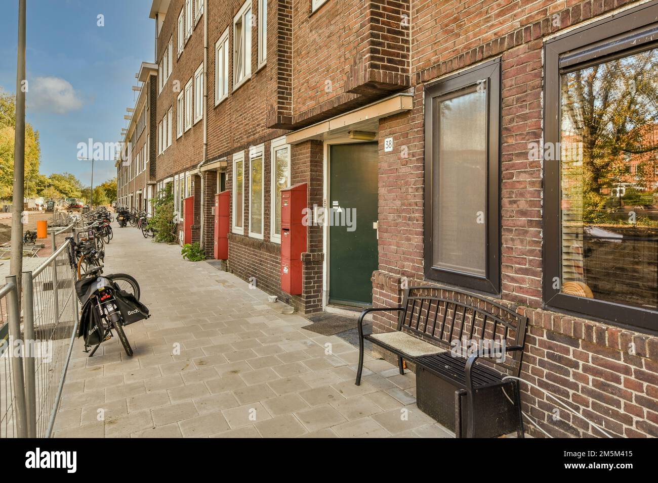 un vélo stationné sur le côté d'une rue devant un bâtiment en briques qui a été peint en rouge et blanc Banque D'Images