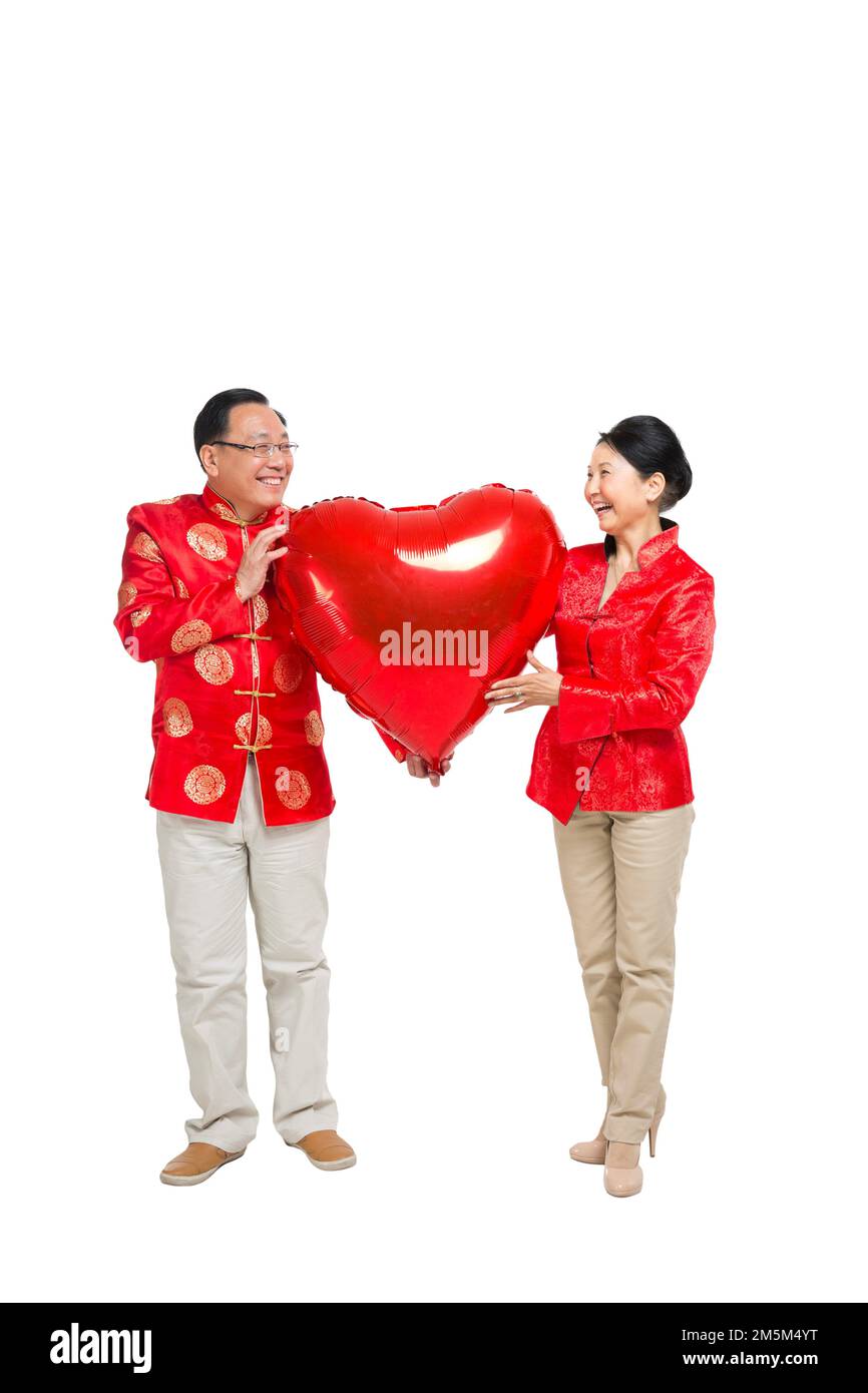 Remise de heureux chinois tenue du nouvel an couples âgés tenant une montgolfière rouge en forme de coeur Banque D'Images