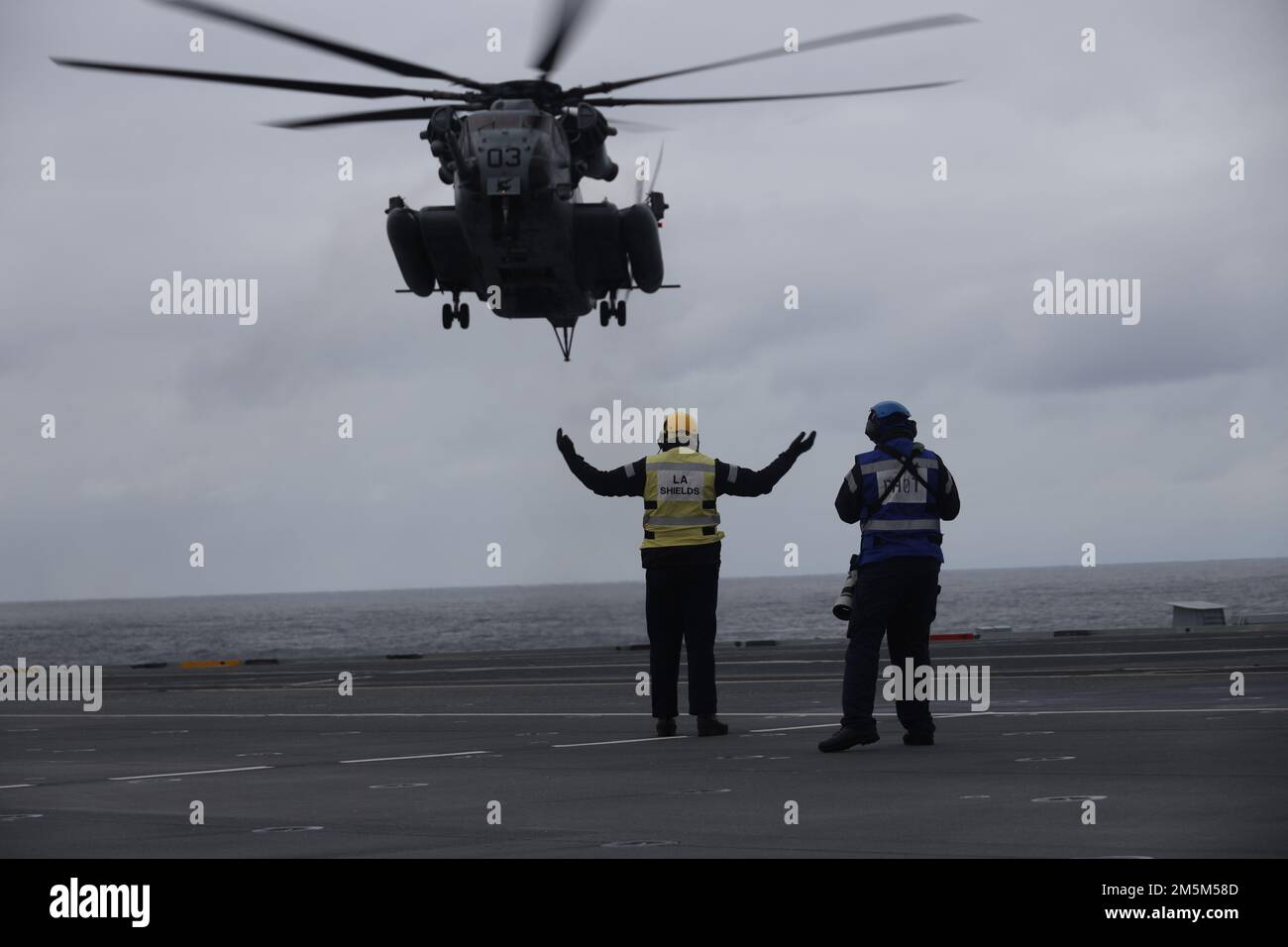 Un marin de la Marine royale du Royaume-Uni signale un atterrissage à un Super Stallion CH-53E pendant l'exercice Cold Response 2022, Mer norvégienne, 24 mars 2022. Le CH-53E Super Stallion est affecté au Marine Heavy Helicopter Squadron (HMH) 366, Marine Aircraft Group 29, 2D Marine Aircraft Wing. L'exercice Cold Response '22 est un exercice biennal de préparation nationale et de défense norvégien qui a lieu dans toute la Norvège, avec la participation de chacun de ses services militaires, ainsi que de 26 autres nations alliées de l'OTAN et partenaires régionaux. Banque D'Images