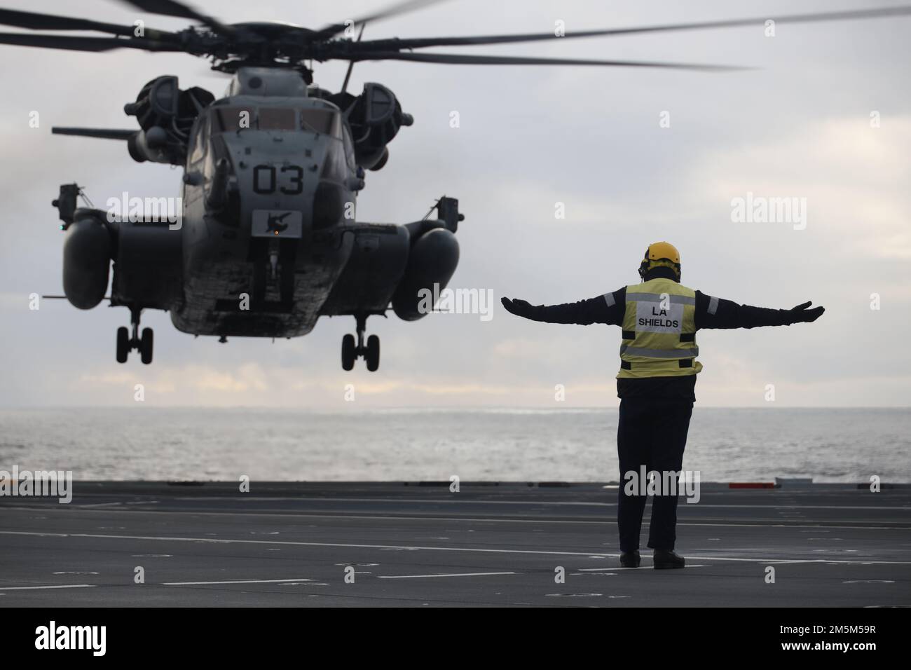 Un marin de la Marine royale du Royaume-Uni signale un atterrissage à un Super Stallion CH-53E pendant l'exercice Cold Response 2022, Mer norvégienne, 24 mars 2022. Le CH-53E Super Stallion est affecté au Marine Heavy Helicopter Squadron (HMH) 366, Marine Aircraft Group 29, 2nd Marine Aircraft Wing. L'exercice Cold Response '22 est un exercice biennal de préparation nationale et de défense norvégien qui a lieu dans toute la Norvège, avec la participation de chacun de ses services militaires, ainsi que de 26 autres nations alliées de l'OTAN et partenaires régionaux. Banque D'Images