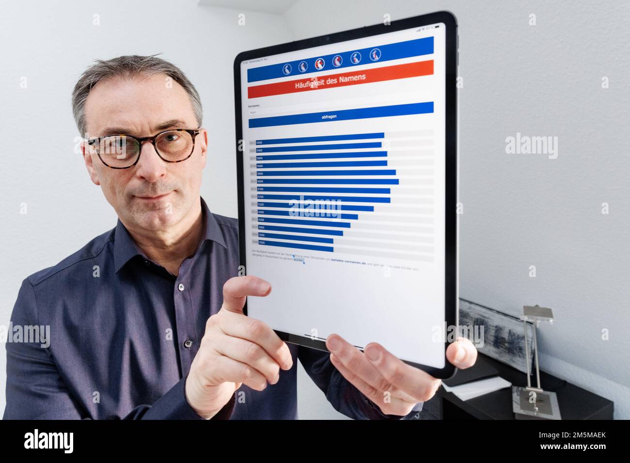 Ahrensburg, Allemagne. 29th décembre 2022. Knud Bielefeld, expert en First name, montre son application Horstomat sur une tablette dans son bureau, où il affiche la fréquence d'un prénom au fil des ans. Il y a eu un léger mouvement dans la liste des 10 premiers noms les plus populaires : Alors que parmi les filles le nom Emilia continue d'être au numéro 1 dans le classement de l'expert de prénom Knud Bielefeld, Noah a maintenant atterri au sommet après 2020 (à dpa 'Emilia et Noah sont les gagnants de premier nom en 2022 - Nelio et Theo sur la hausse"). Credit: Markus Scholz/dpa/Alay Live News Banque D'Images