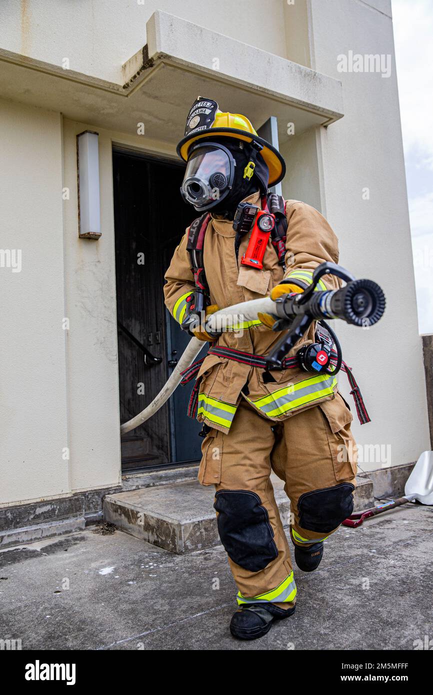 Un pompier avec des installations de corps de Marines les services d'incendie et d'urgence du Pacifique réagissent à un incendie lors d'un exercice bilatéral d'entraînement en direct à Camp Hansen, Okinawa, Japon, 25 mars 2022. Le CMCIPAC F&ES et le service des incendies de la ville de Naha ont rassemblé et organisé une formation en direct sur les incendies afin de comparer les différentes techniques et méthodes de lutte contre les incendies utilisées par chaque service pour accomplir la même mission. Banque D'Images