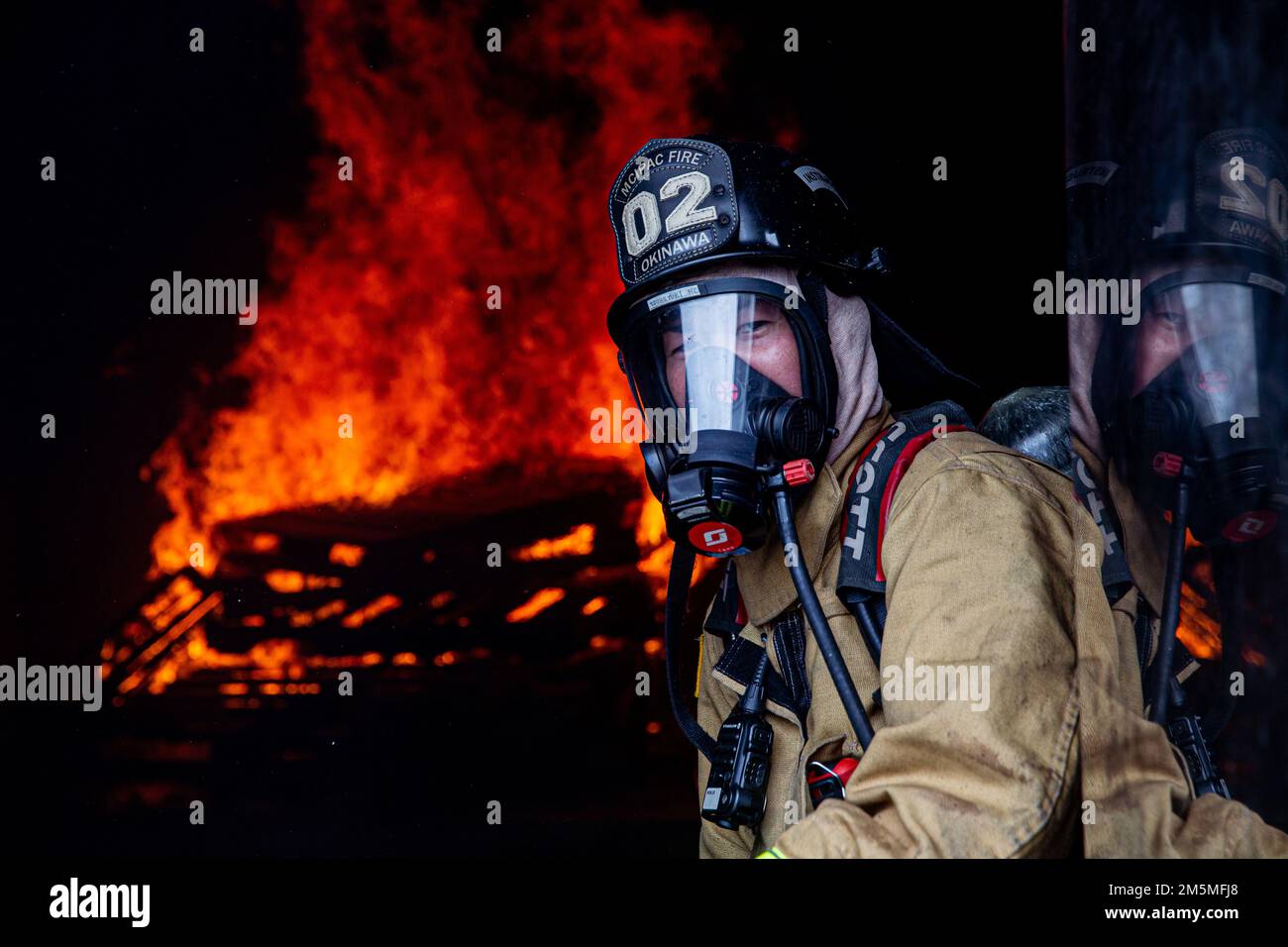 Un pompier avec des installations de corps de Marines Pacific Fire and Emergency Services observe une salle de combustion lors d'un exercice bilatéral d'entraînement en direct sur le camp Hansen, Okinawa, Japon, 25 mars 2022. Le CMCIPAC F&ES et le service des incendies de la ville de Naha ont rassemblé et organisé une formation en direct sur les incendies afin de comparer les différentes techniques et méthodes de lutte contre les incendies utilisées par chaque service pour accomplir la même mission. Banque D'Images