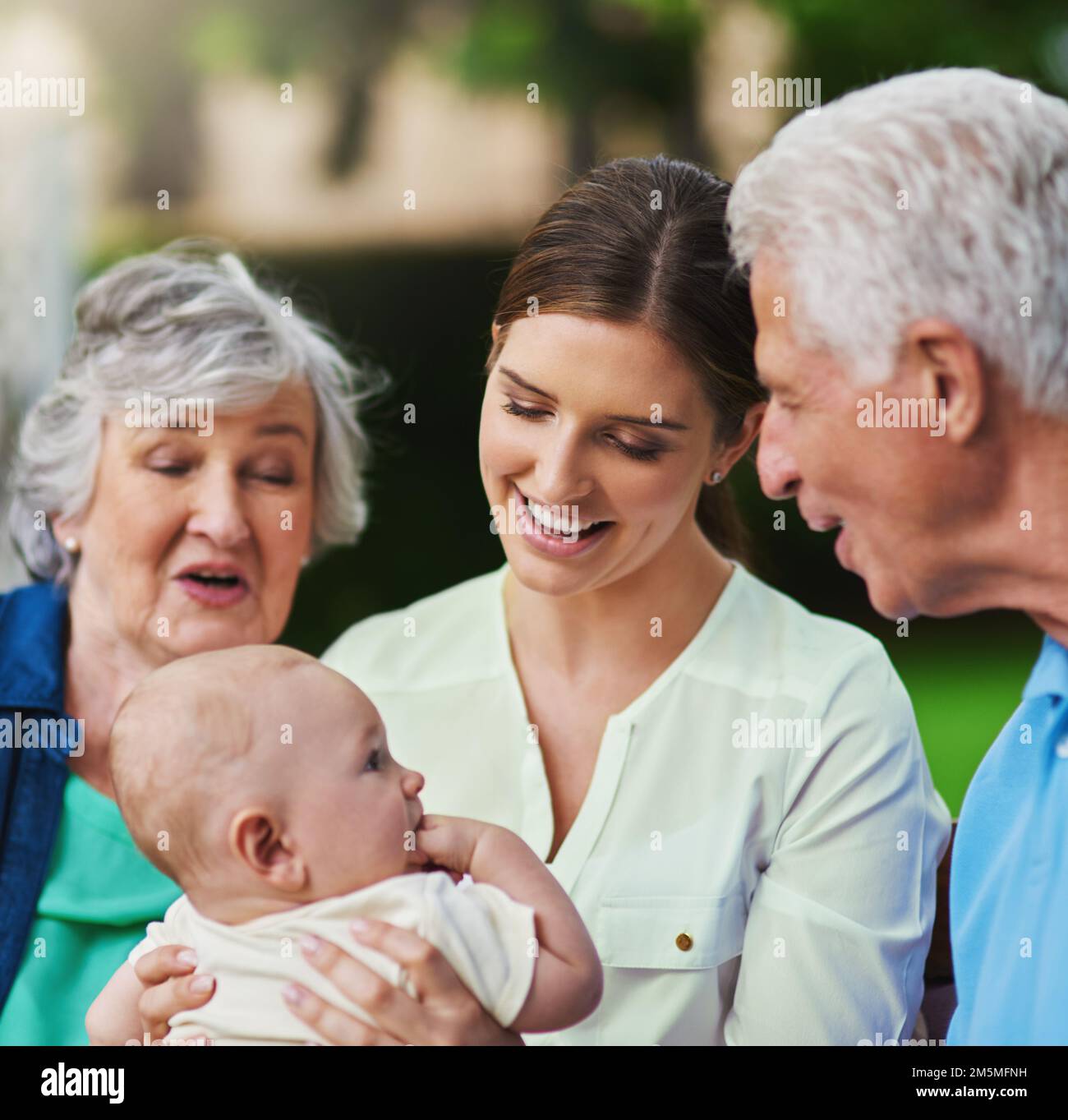 Ils ne peuvent tout simplement pas obtenir assez de sa cutesse. une famille de trois générations passant du temps à l'extérieur. Banque D'Images