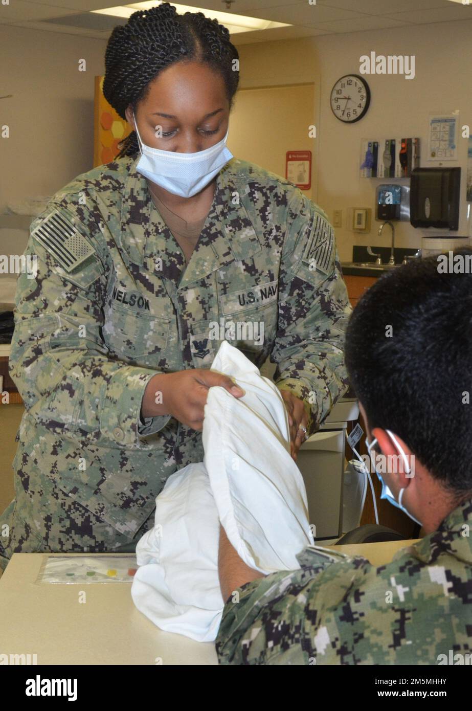 JACKSONVILLE, Floride (25 mars 2022) - classe 2nd de l'Hôpital Corpsman Kimberly Nelson, assistante en ergothérapie à la clinique d'ergothérapie de l'Hôpital naval de Jacksonville, applique de la chaleur et du poids au poignet du patient. Nelson, originaire d’Allen, Texas, déclare : « nous nous efforçons de faire en sorte que les patients reviennent à leurs activités quotidiennes et puissent accomplir leur travail. » Banque D'Images