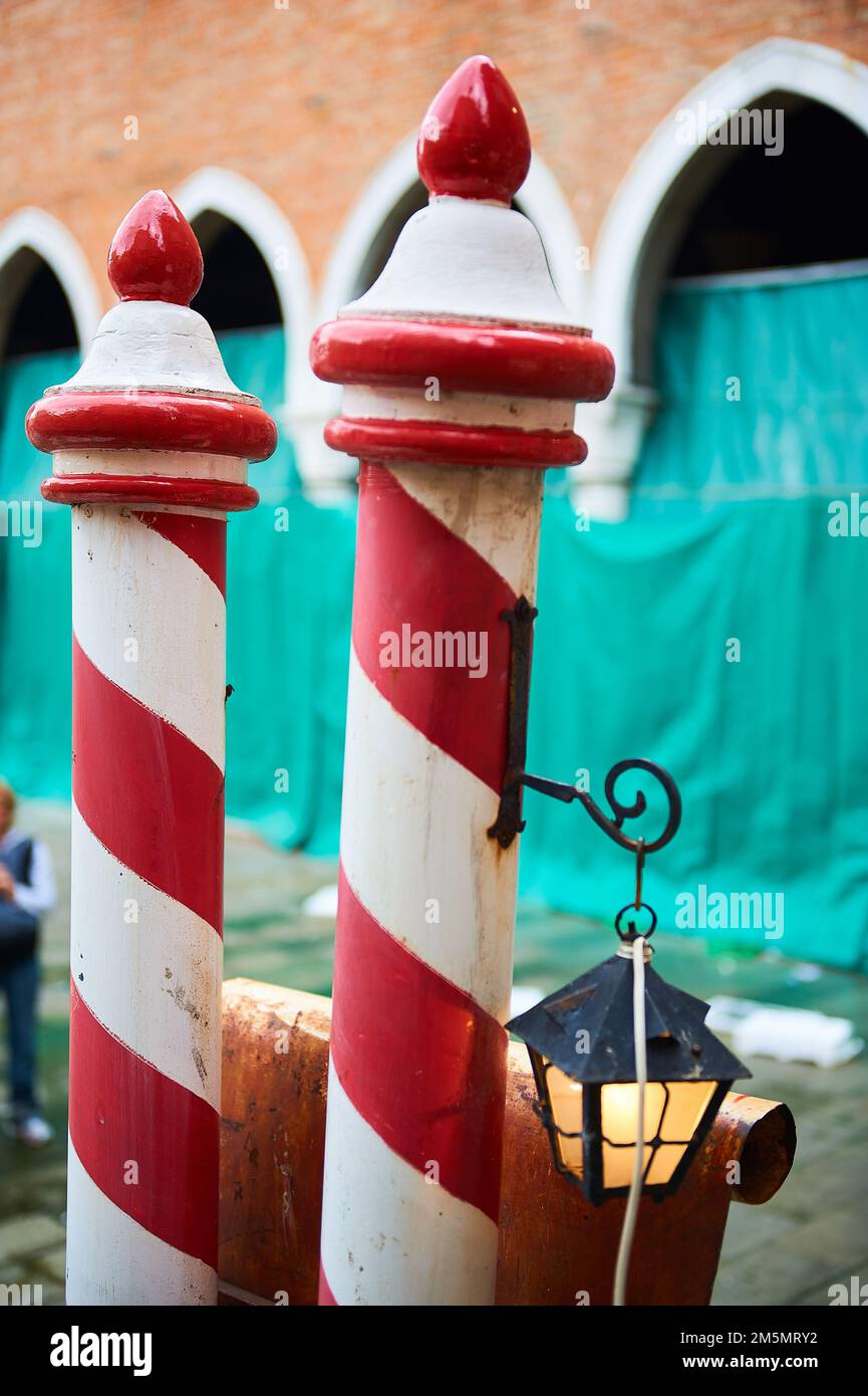 L'amarrage des bateaux typiques de poteaux en rouge et blanc à côté du marché du Rialto à Venise Banque D'Images