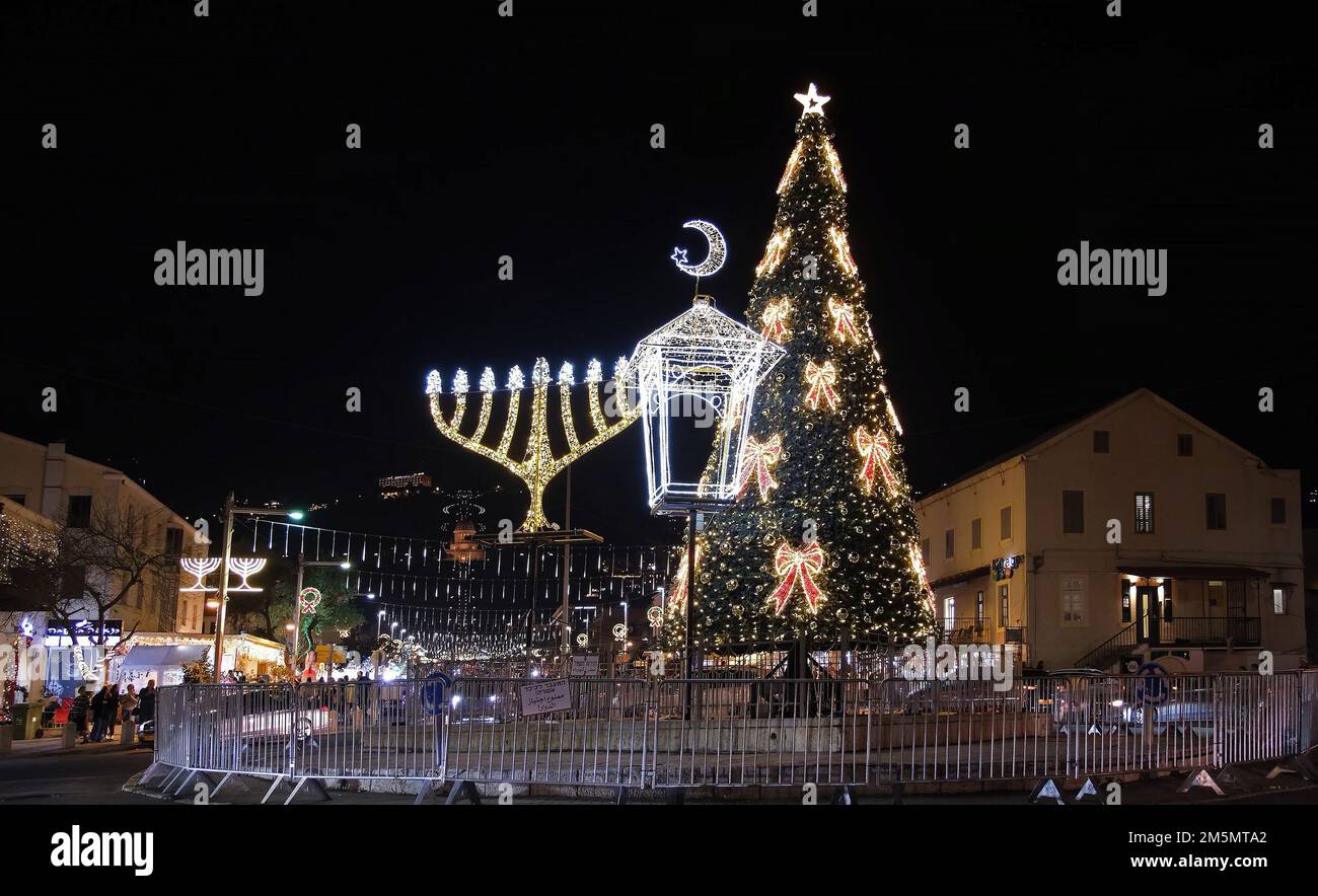 Un arbre de Noël décoré avec la menorah Hanukkah illuminée et le croissant de la nouvelle lune qui est associée à l'islam exposé dans le quartier de la colonie allemande à Haïfa, Israël comme la ville célèbre les vacances qui marque les vacances Hanukkah, Noël, et Ramadan vacances de trois religions principales: Christianisme, judaïsme et islam. Banque D'Images