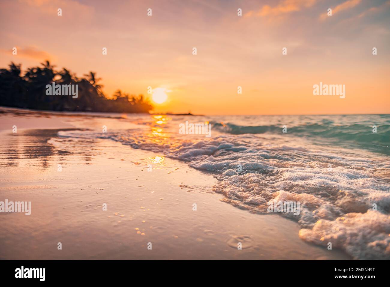 Fantastique vue rapprochée des vagues calmes de l'eau de mer avec le soleil orange du lever du soleil au coucher du soleil. Paysage de plage d'île tropicale, côte exotique de rivage. Vacances estivales Banque D'Images