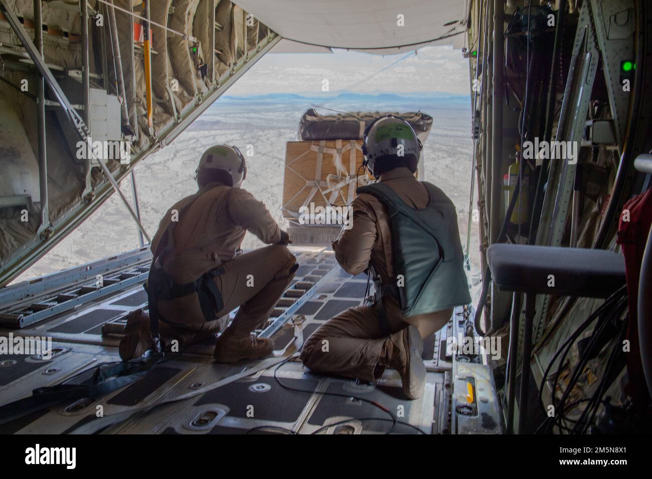 ÉTATS-UNIS Corps maritime Cpl. James Copeland Jr., à gauche, un maître d'équipage d'aéronef à voilure fixe KC-130 de Cartersville (Géorgie), Et le sergent Timothy Leidecker, un mécanicien de bord, tous deux affectés à l'escadron 1 des armes et tactiques de l'aviation maritime (MAWTS-1), observent une chute d'approvisionnement au cours des opérations STOVL distribuées (ASM), en soutien au cours 2-22 de l'instructeur d'armes et de tactiques (WTI), près de Yuma, en Arizona, au 29 mars 2022. WTI est un événement de formation de sept semaines organisé par MAWTS-1, offrant une formation tactique avancée standardisée et une certification des qualifications des instructeurs de l'unité pour soutenir Marine avia Banque D'Images