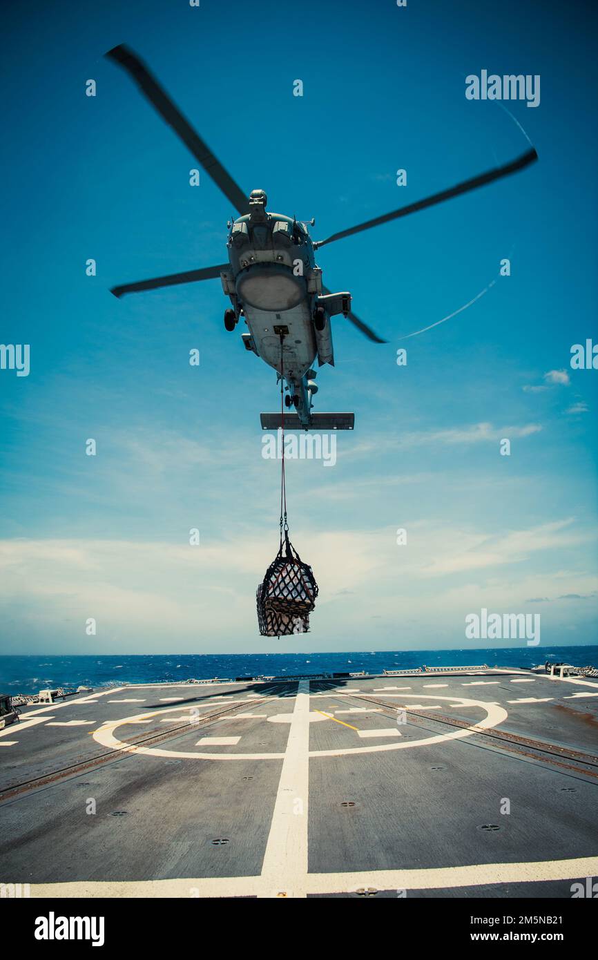 220330-N-TT059-2052 MER DE CHINE DU SUD (30 mars 2022) Un hélicoptère MH-60R Sea Hawk de l'escadron de frappe maritime des hélicoptères (HSM) 35 livre des cargaisons durant les opérations de réapprovisionnement vertical (VERTREP) à bord du destroyer à missiles guidés USS Momsen (DDG 92). Momsen est affecté au Commandant de la Force opérationnelle 71/Escadrier Squadron (DESRON) 15, le plus grand DESRON déployé à l'avant de la Marine et la principale force de combat de la flotte américaine 7th, et est en cours de soutien à une Indo-Pacific libre et ouverte. Banque D'Images