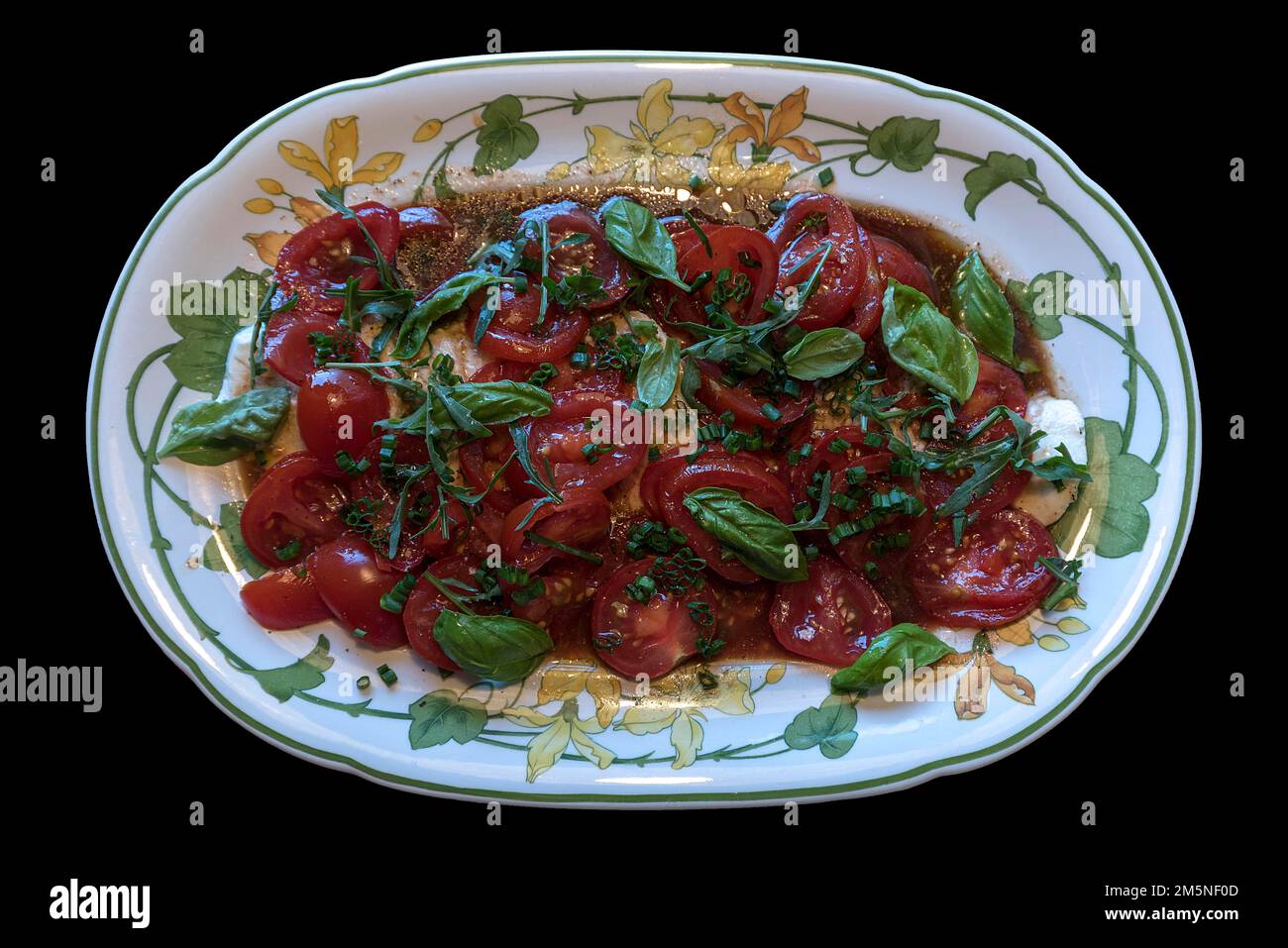 Mozzarella aux tomates et basilic sur une assiette ovale, sur fond noir, Bavière, Allemagne Banque D'Images