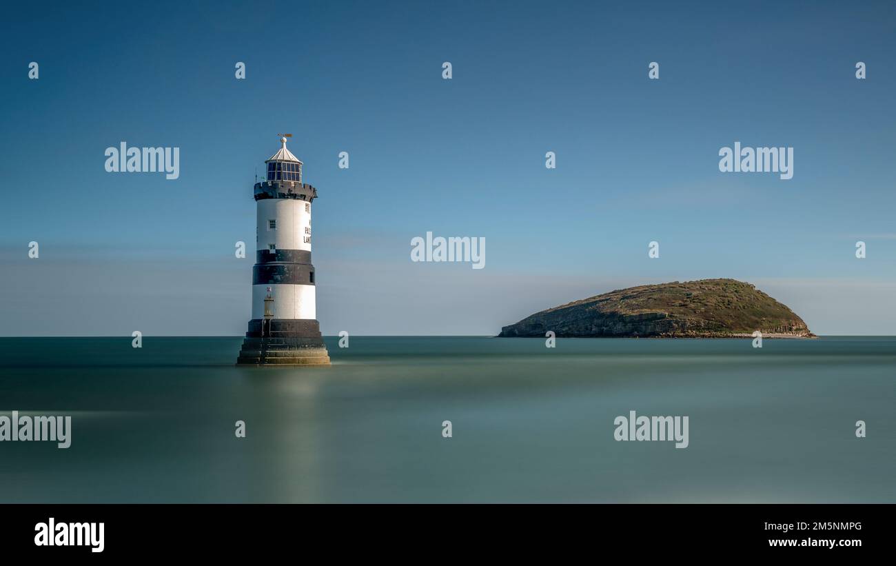 Phare de Penmon Point sur la côte d’Anglesey dans le nord du Pays de Galles, surplombant le détroit de Menai et l’île Puffin. Banque D'Images