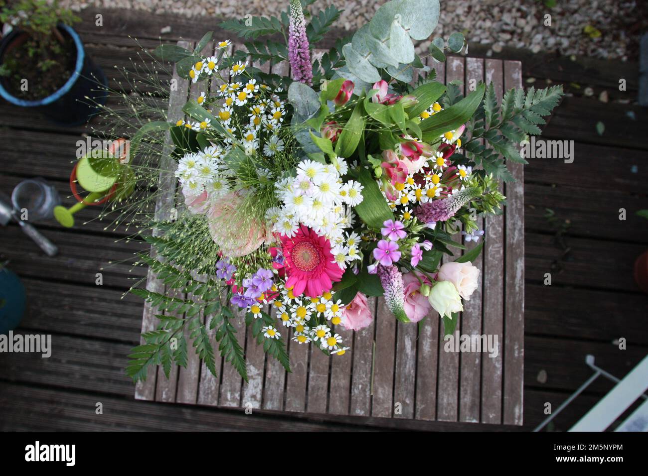 Beau bouquet floral dans un vase sur une table de jardin dans un jardin de cour anglaise Banque D'Images