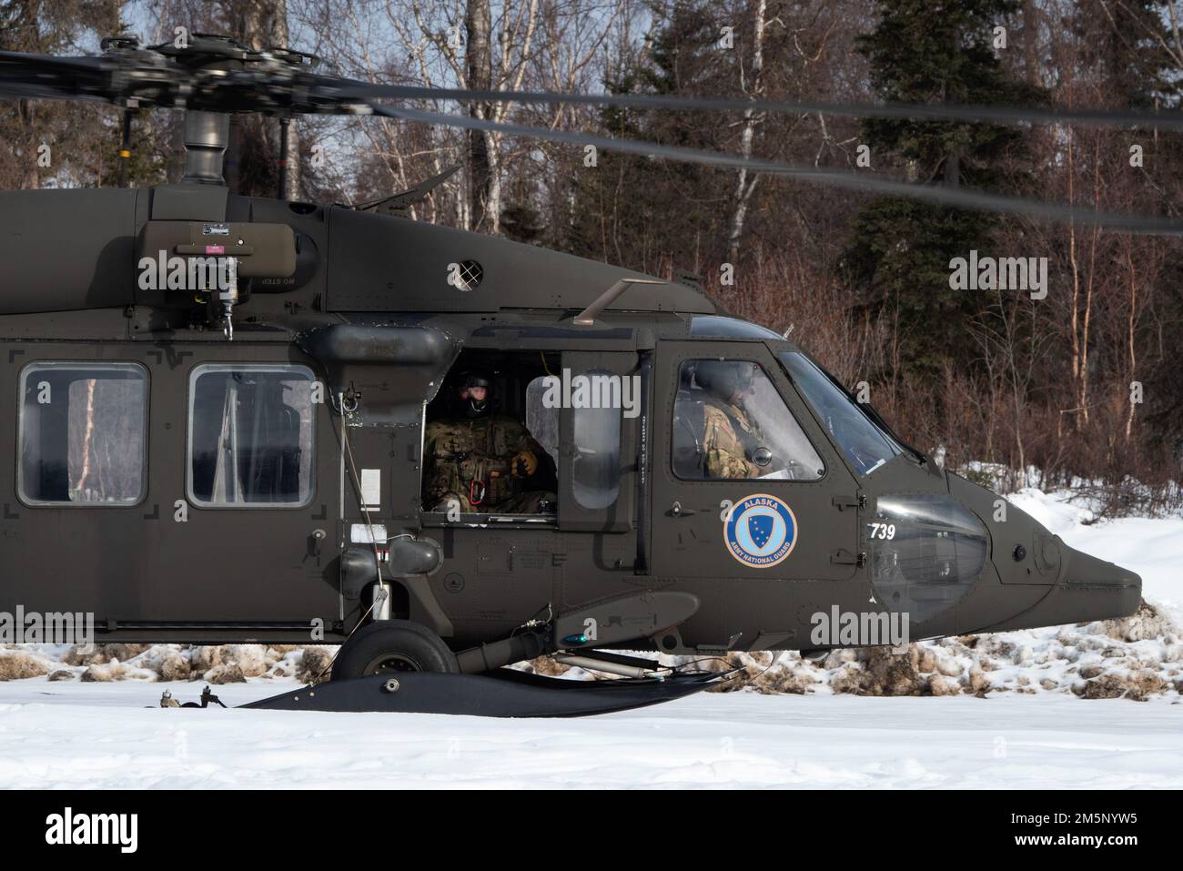 Un hélicoptère de la Garde nationale de l'Armée de l'Alaska UH-60L Black Hawk exploité par l'équipage de l'aviation affecté au Commandement de la troupe d'aviation 207th se prépare à quitter Camp Mad Bull tout en appuyant un exercice d'entraînement sur le terrain conjoint à la base interarmées Elmendorf-Richardson, Alaska, le 26 février 2022. Des ingénieurs de la Force aérienne du Groupe du génie civil de 673d et des gardes nationaux de l'Armée de l'Alaska du détachement de services techniques du génie de 207th ont mené la formation conjointe sur les opérations afin de démontrer les compétences nécessaires à la préparation de la mission dans les conditions arctiques. Banque D'Images