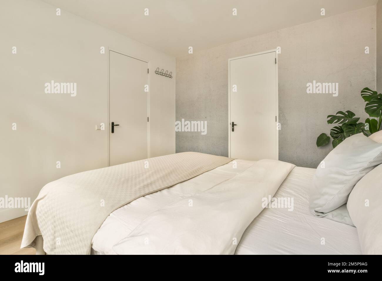 un lit avec des draps blancs et des oreillers dans une chambre qui n'a pas un mur ou une porte sur le côté droit Banque D'Images
